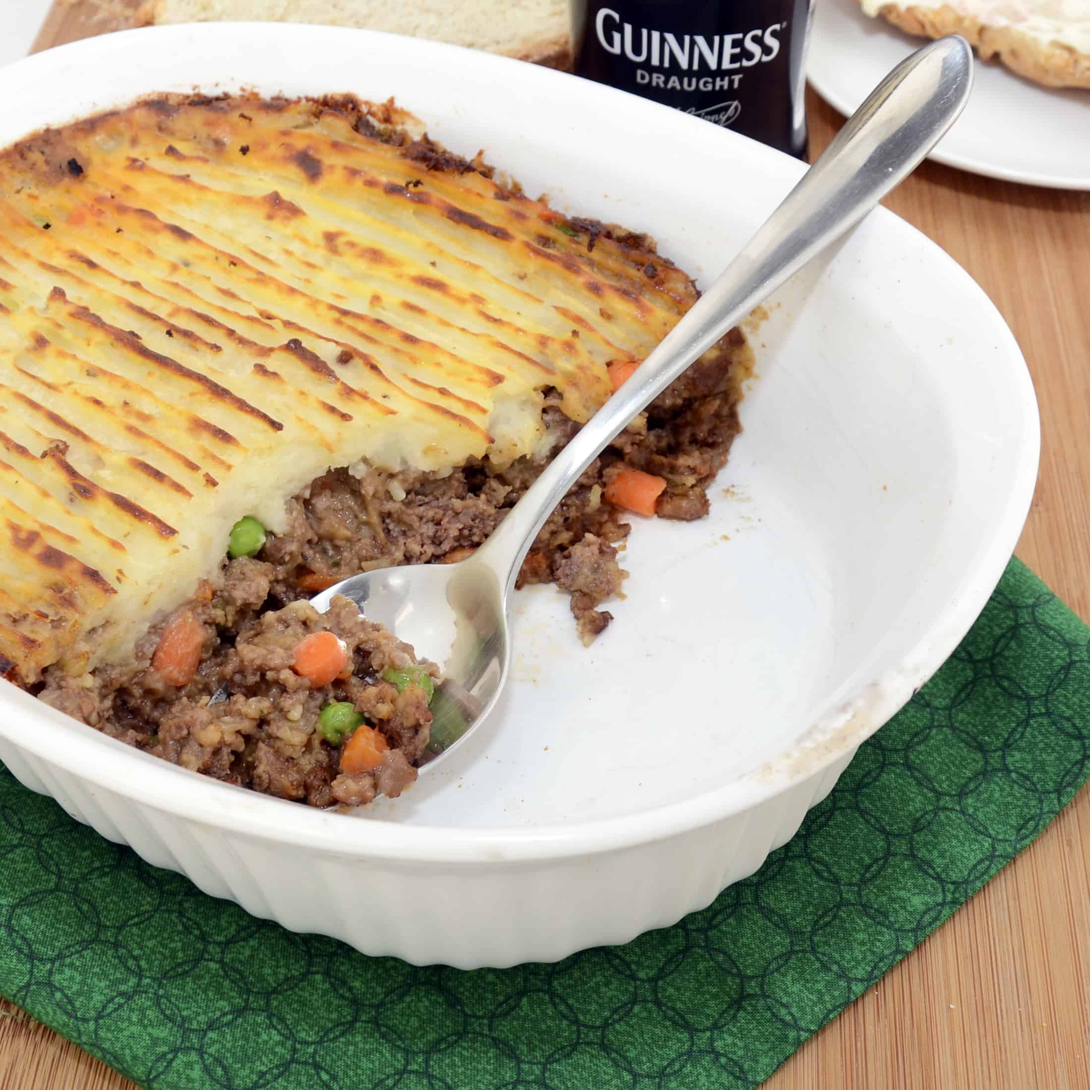 shepperd's pie in a white casserole dish with a green towel