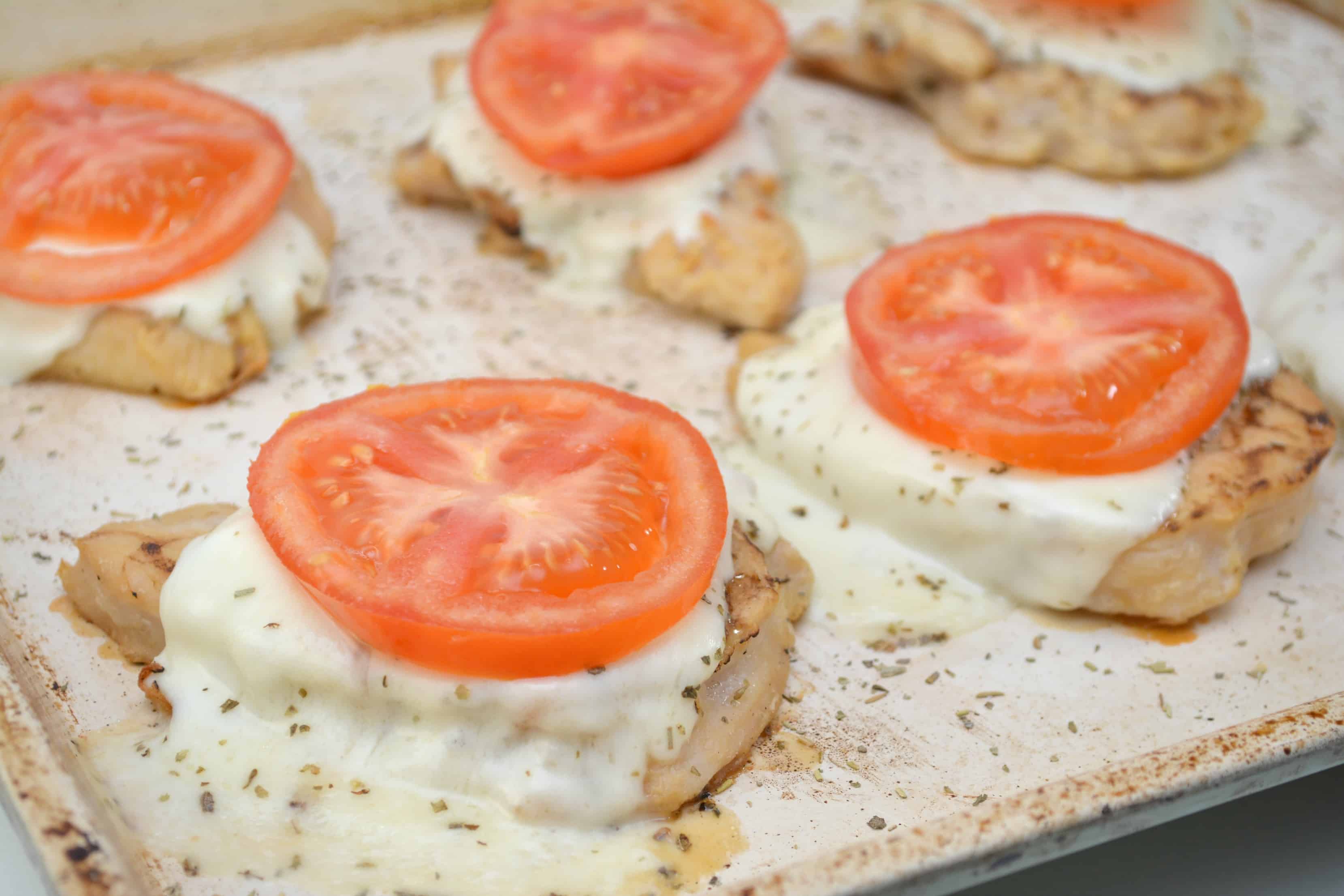 topping chicken caprese with tomatoes