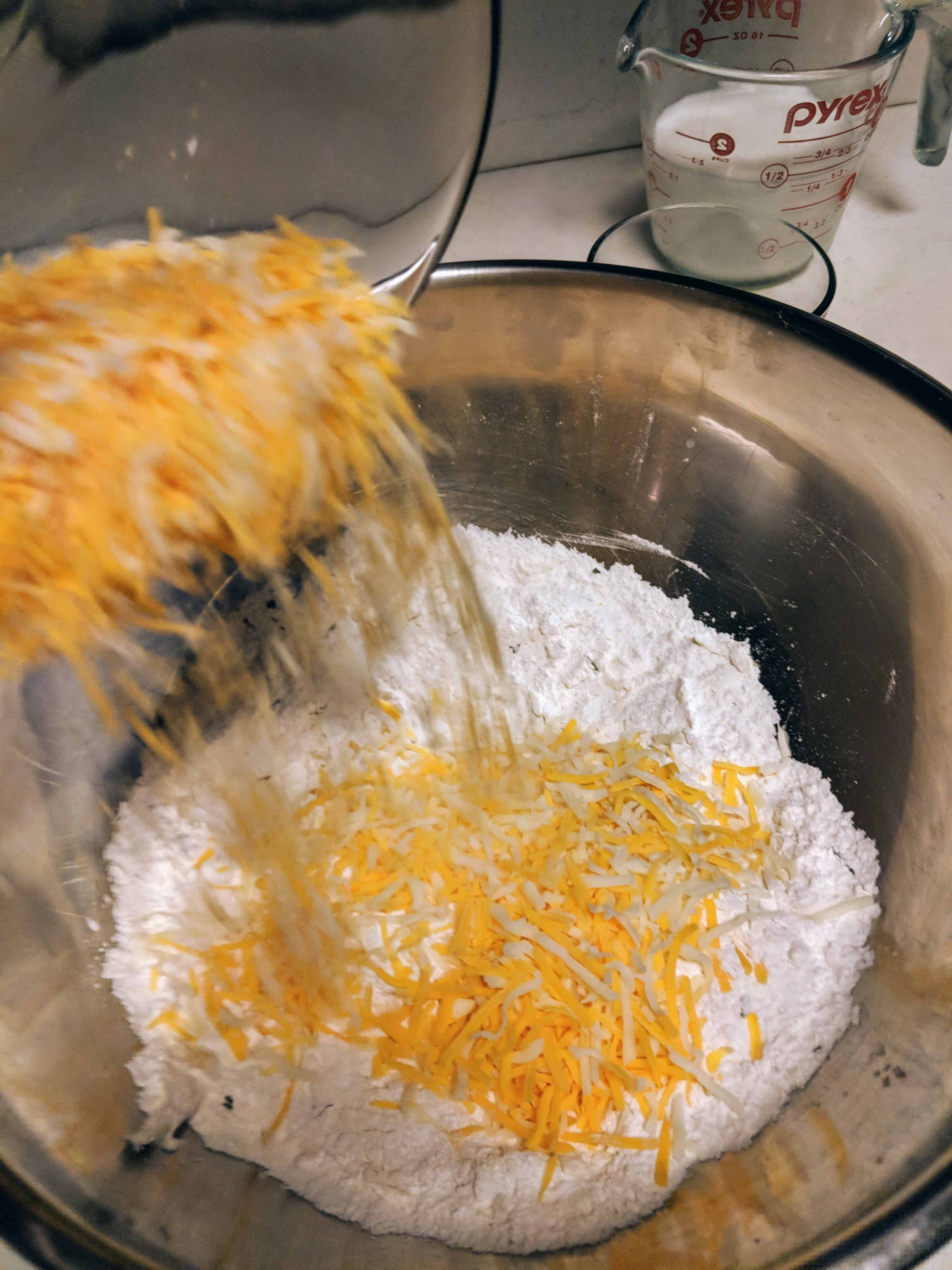 Add shredded cheese to the dry ingredients and butter. Mix well.