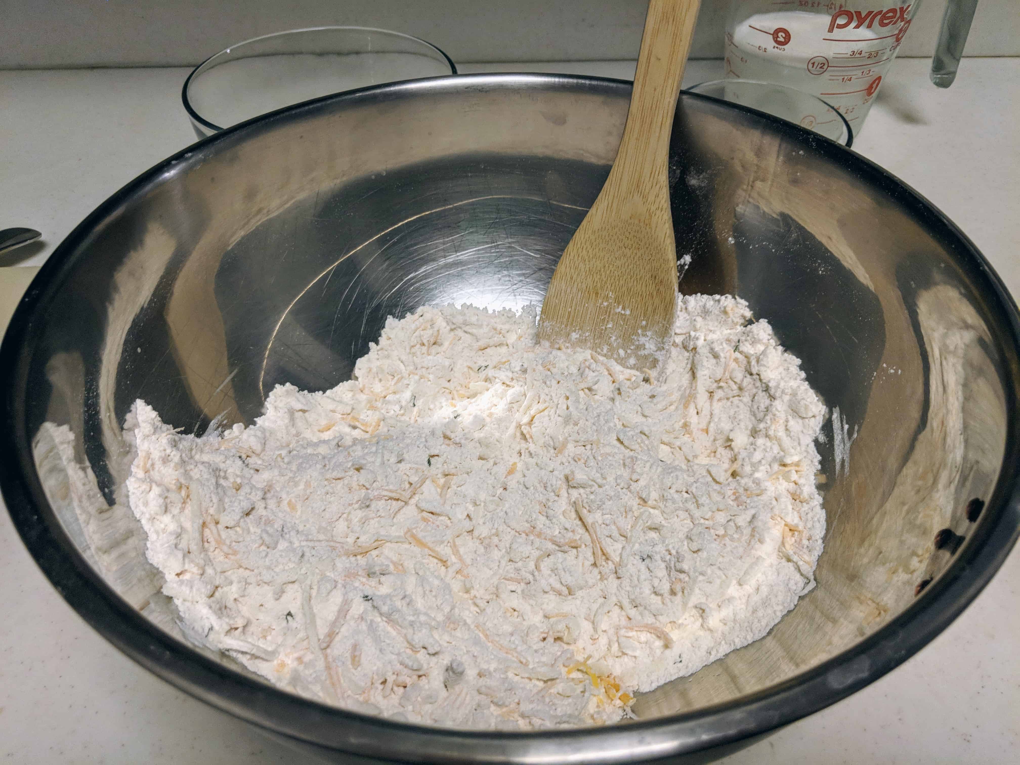 Add shredded cheese to the dry ingredients and butter. Mix well.