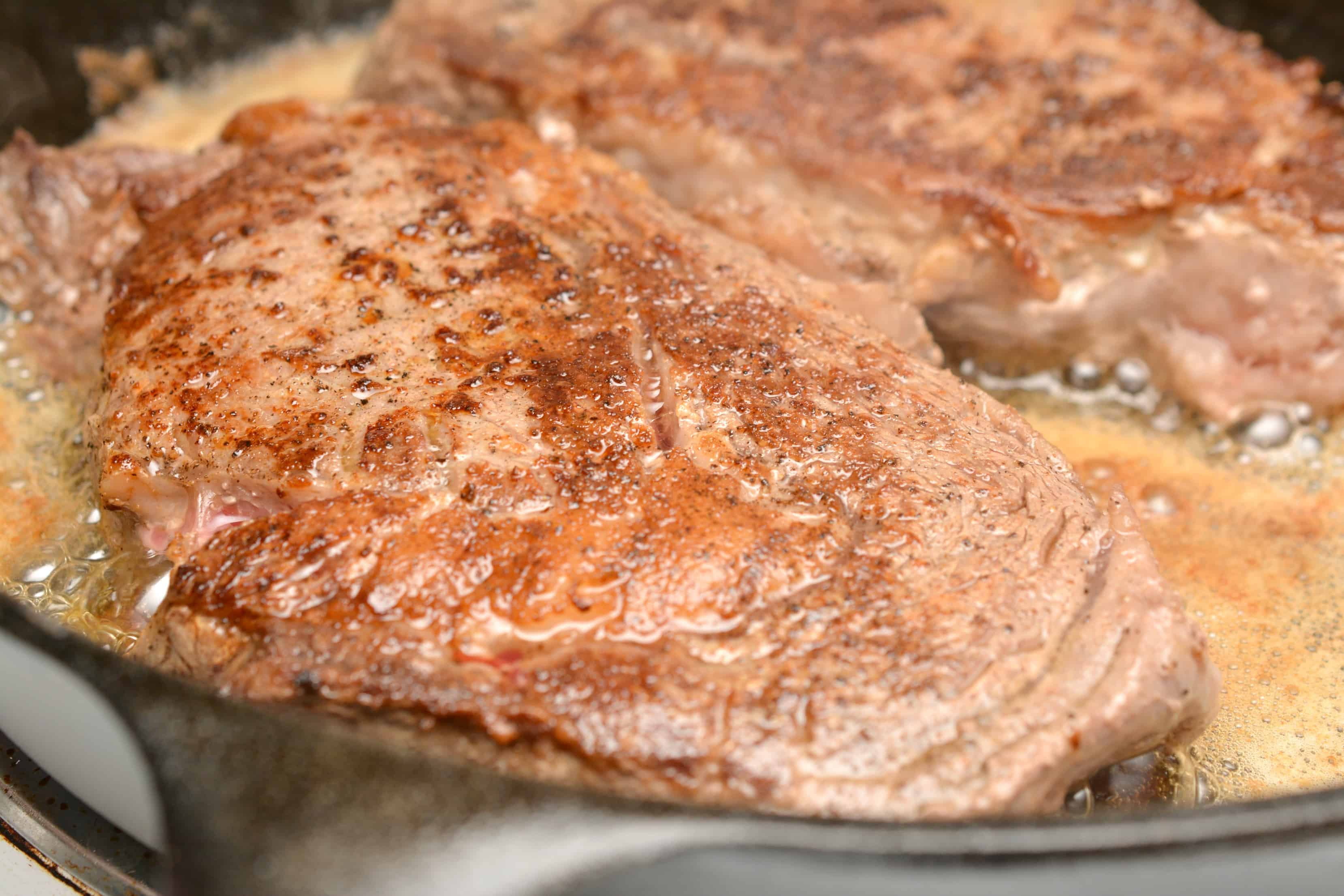 cooking steak in cast iron pan