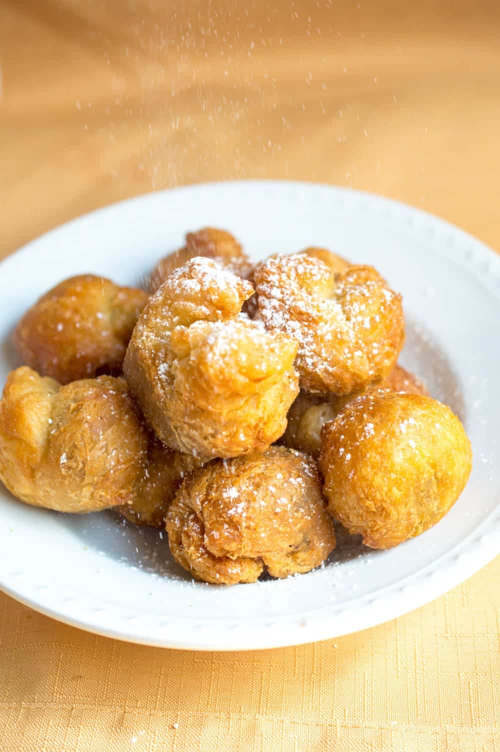 fried nutella dumplings on a plate with powdered sugar on top