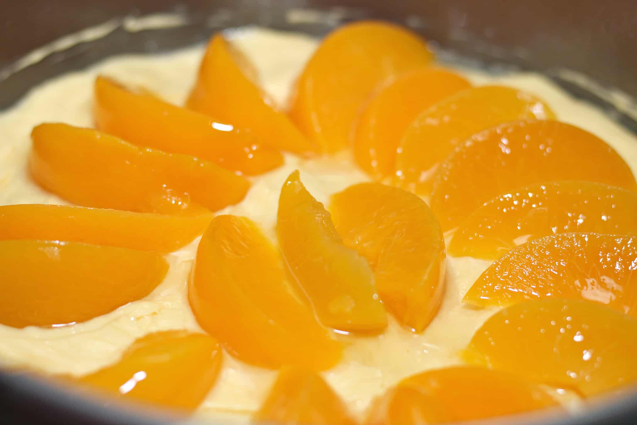 layer of cheesecake with peaches on top