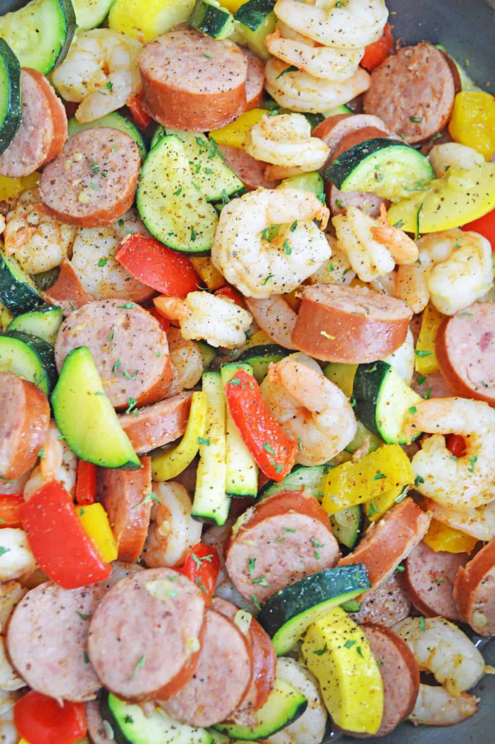 shrimp and sausage recipe in a pan with seasoning on top
