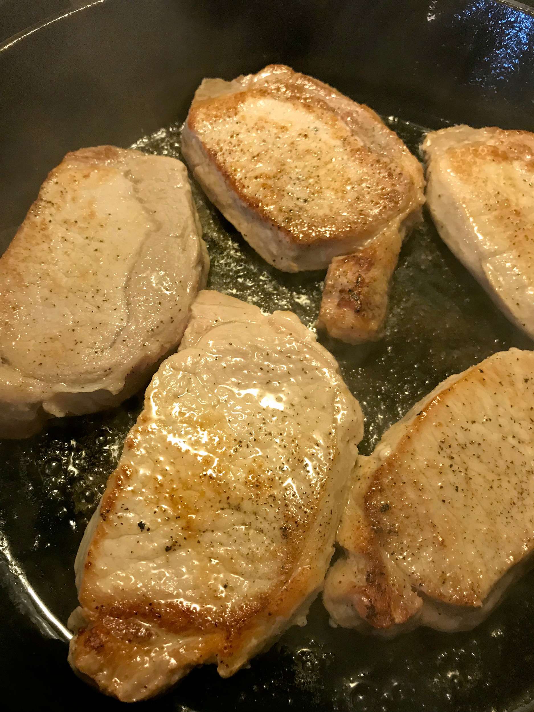 browning pork chops in a skillet