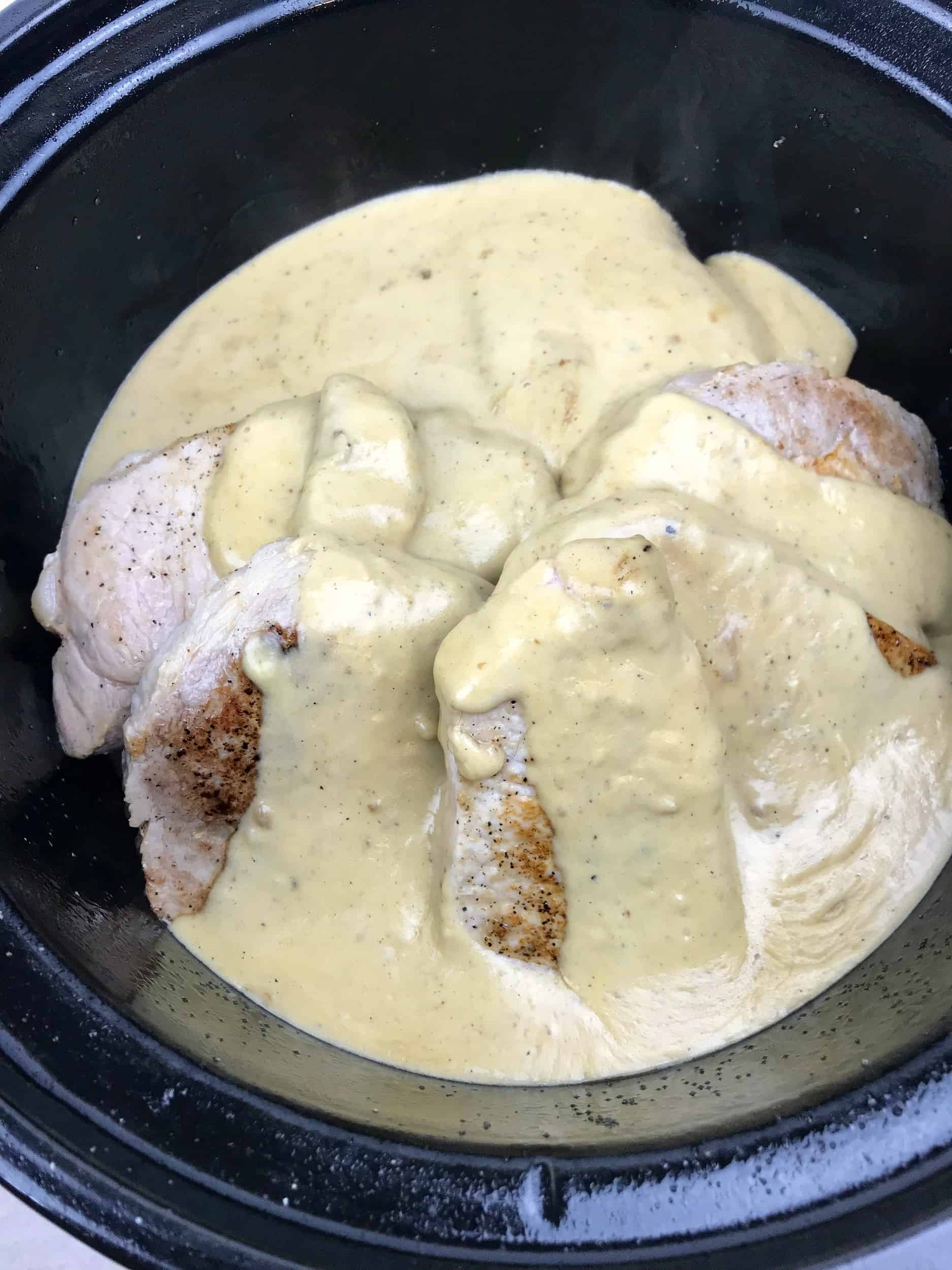 slow cooker porkchops with a cream sauce poured over them 