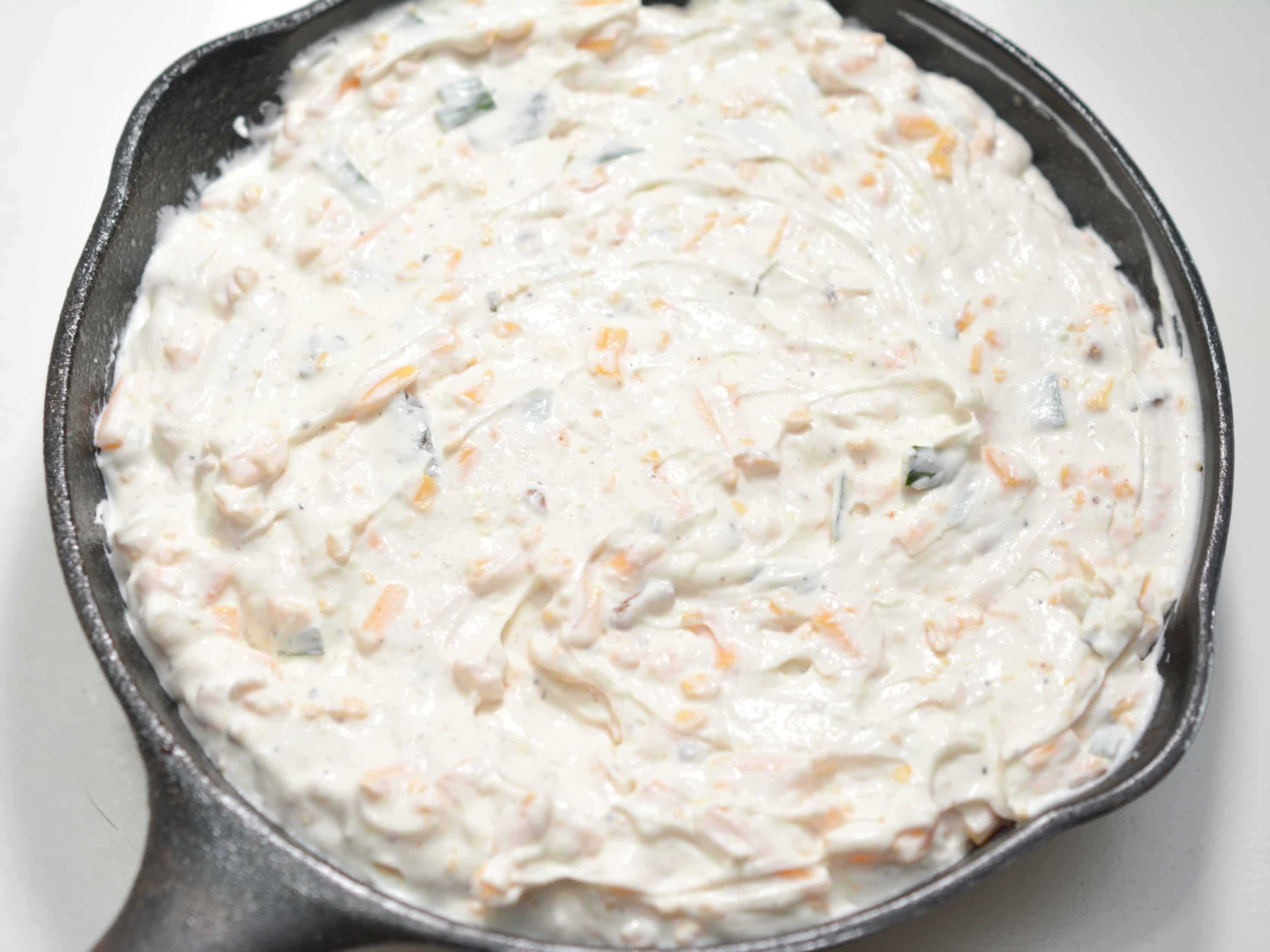 cheese dip mixture in a cast iron pan