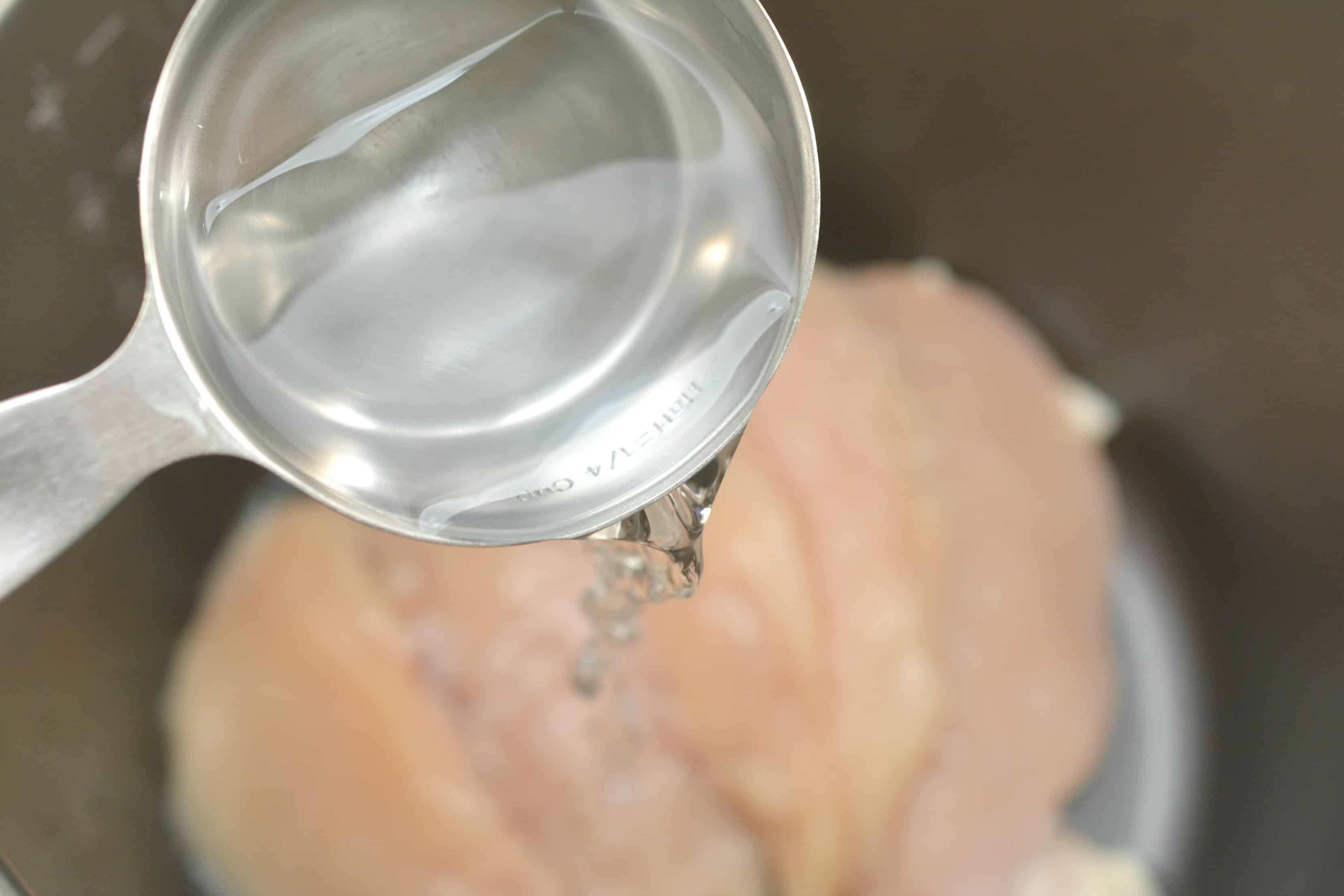 water being poured over chicken
