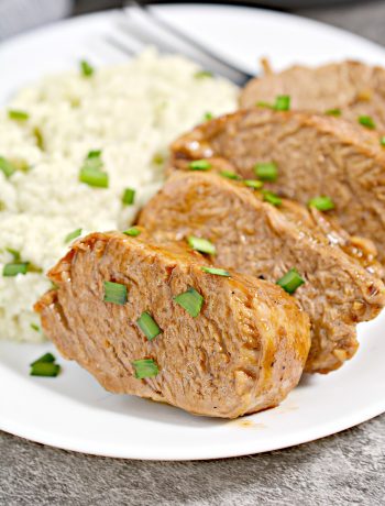 A white plate with instant pot pork loin slices and rice