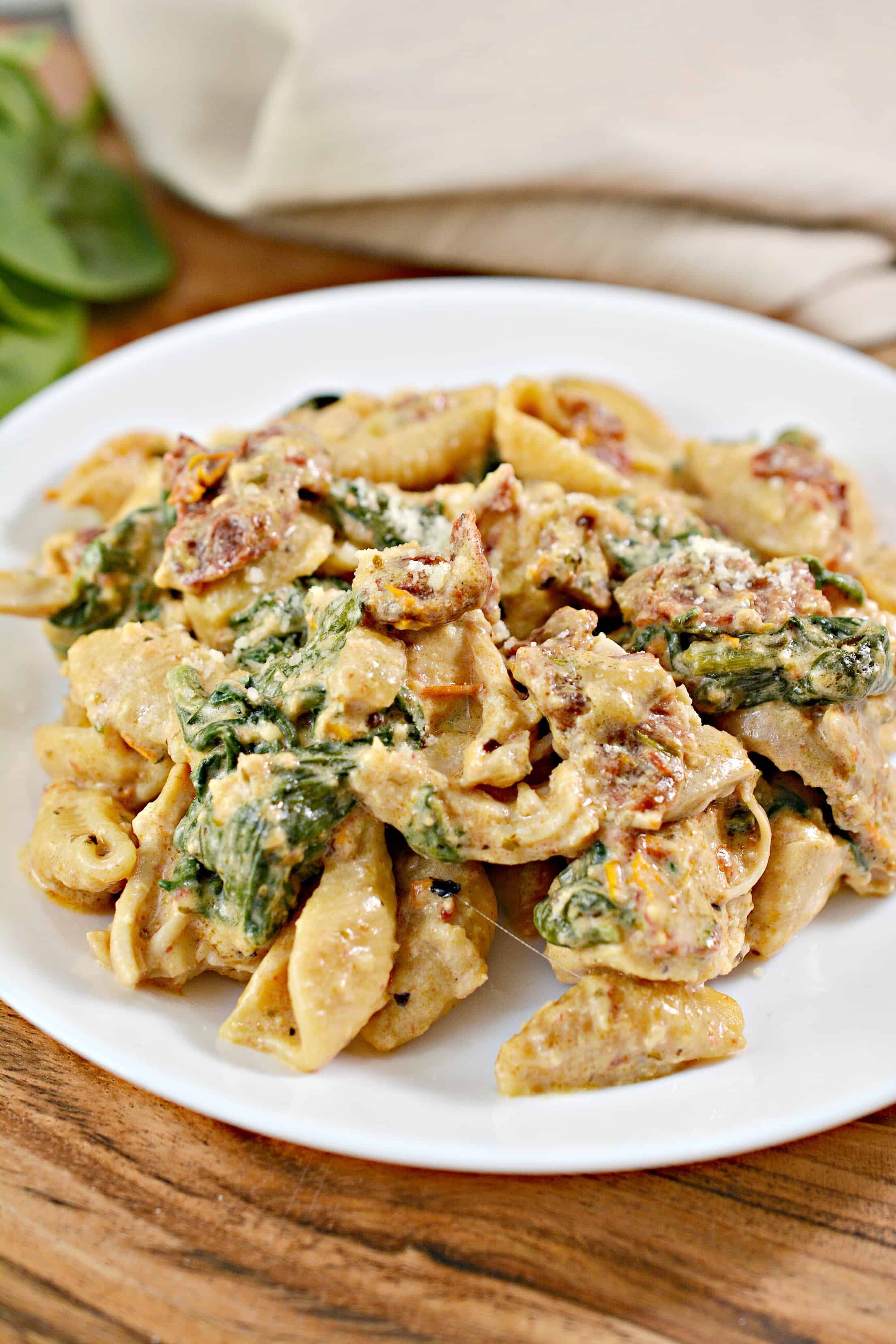 chicken tuscan pasta on a white plate