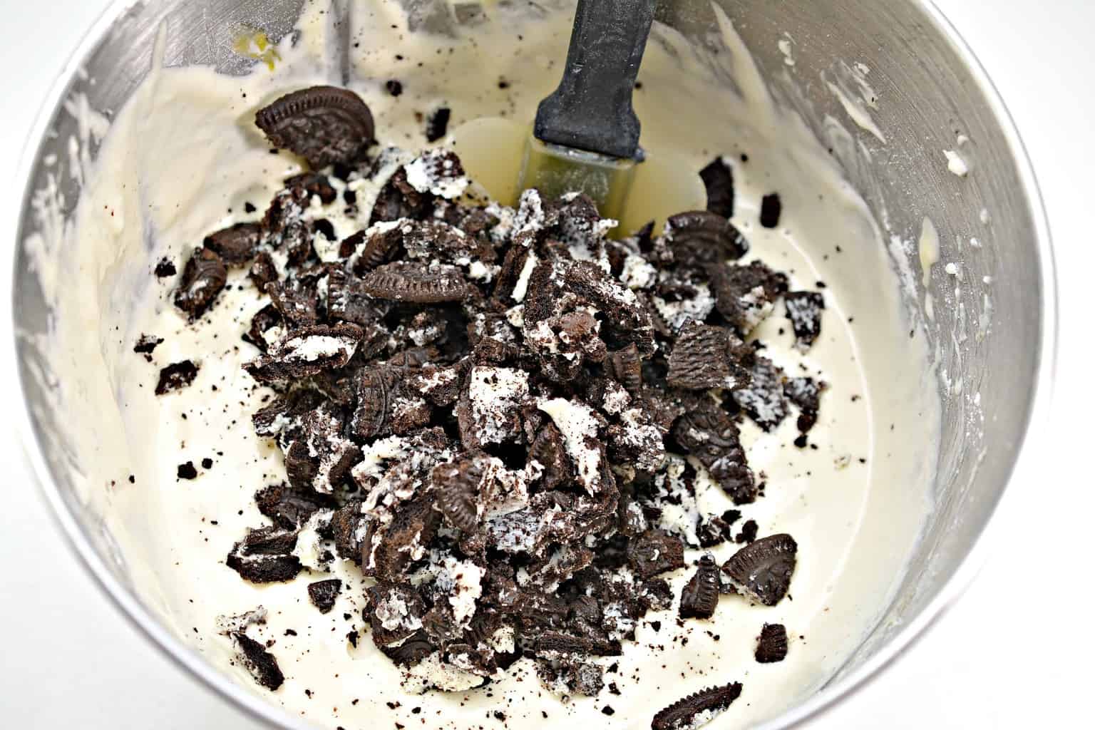 cookies being mixed into cheesecake batter