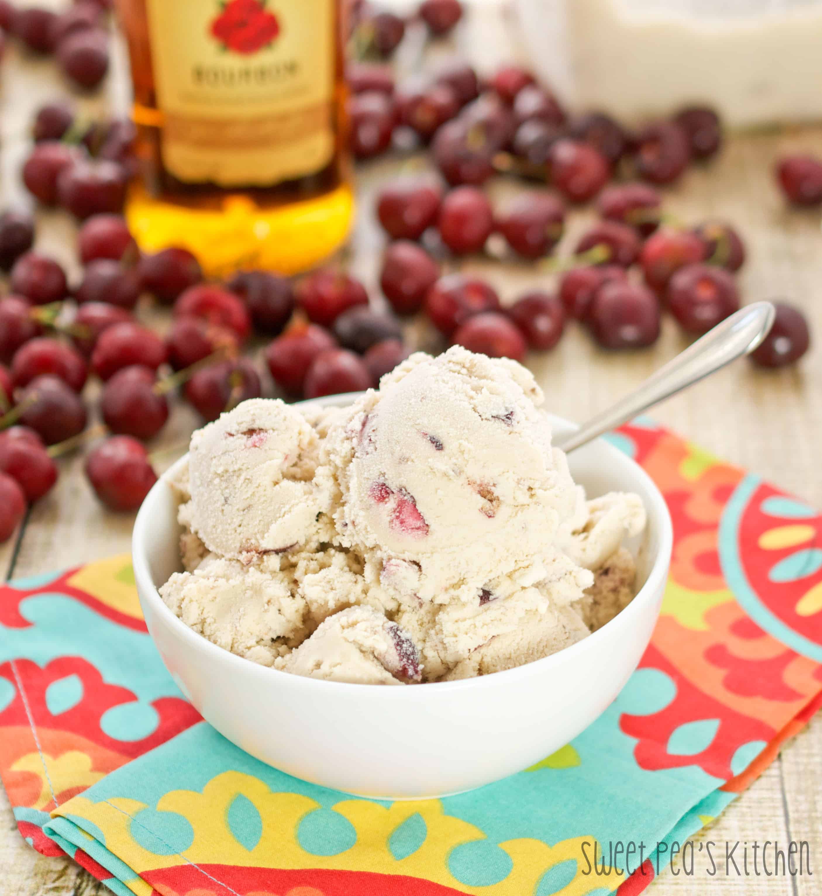 easy cherry ice cream in a white bowl with cherries on the table and a colorful napkin