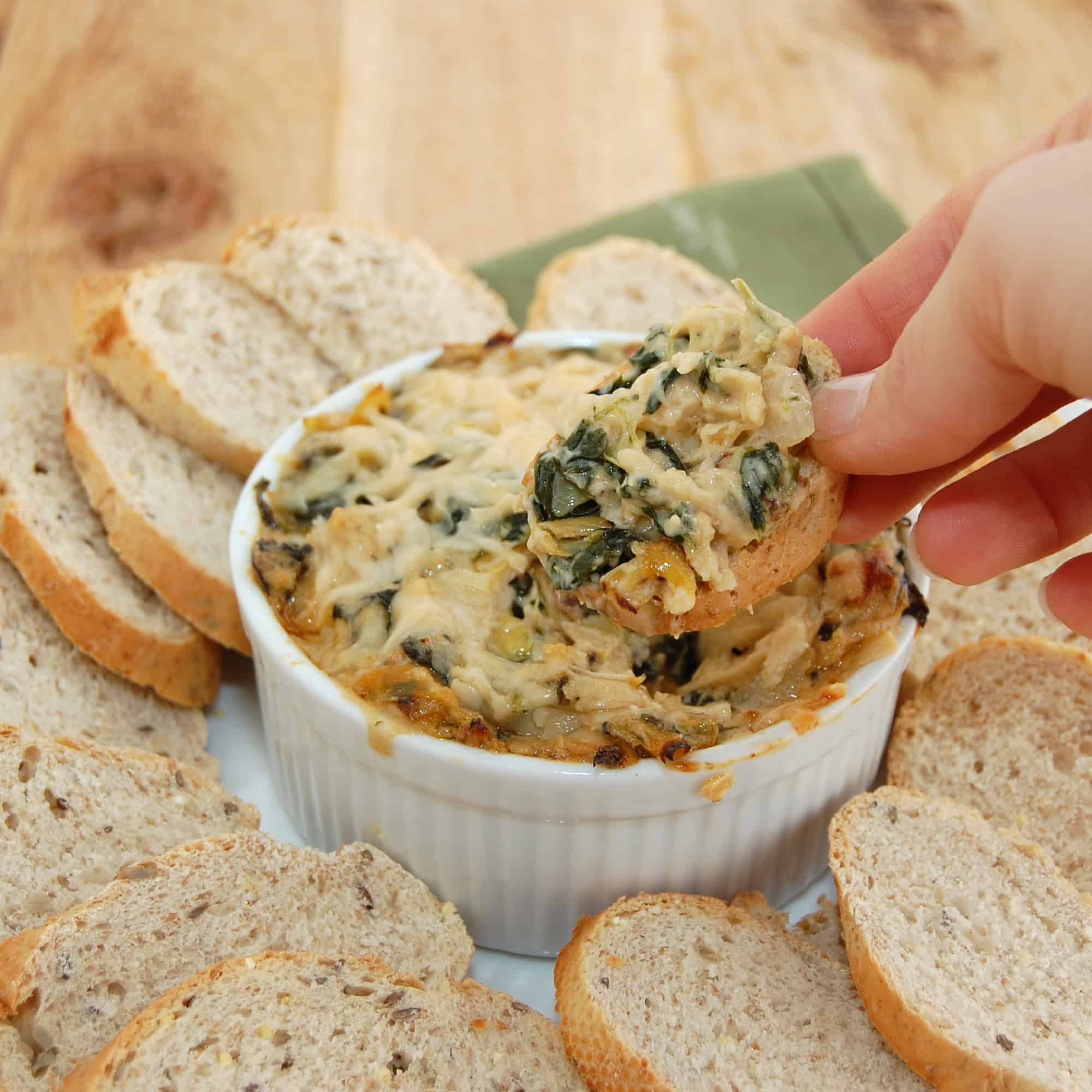 dipping bread into spinach dip