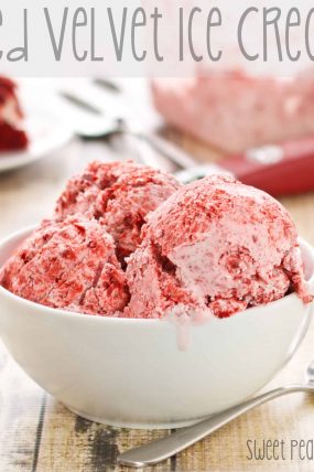 Up close picture of red velvet ice cream sitting with spoon on wooden surface