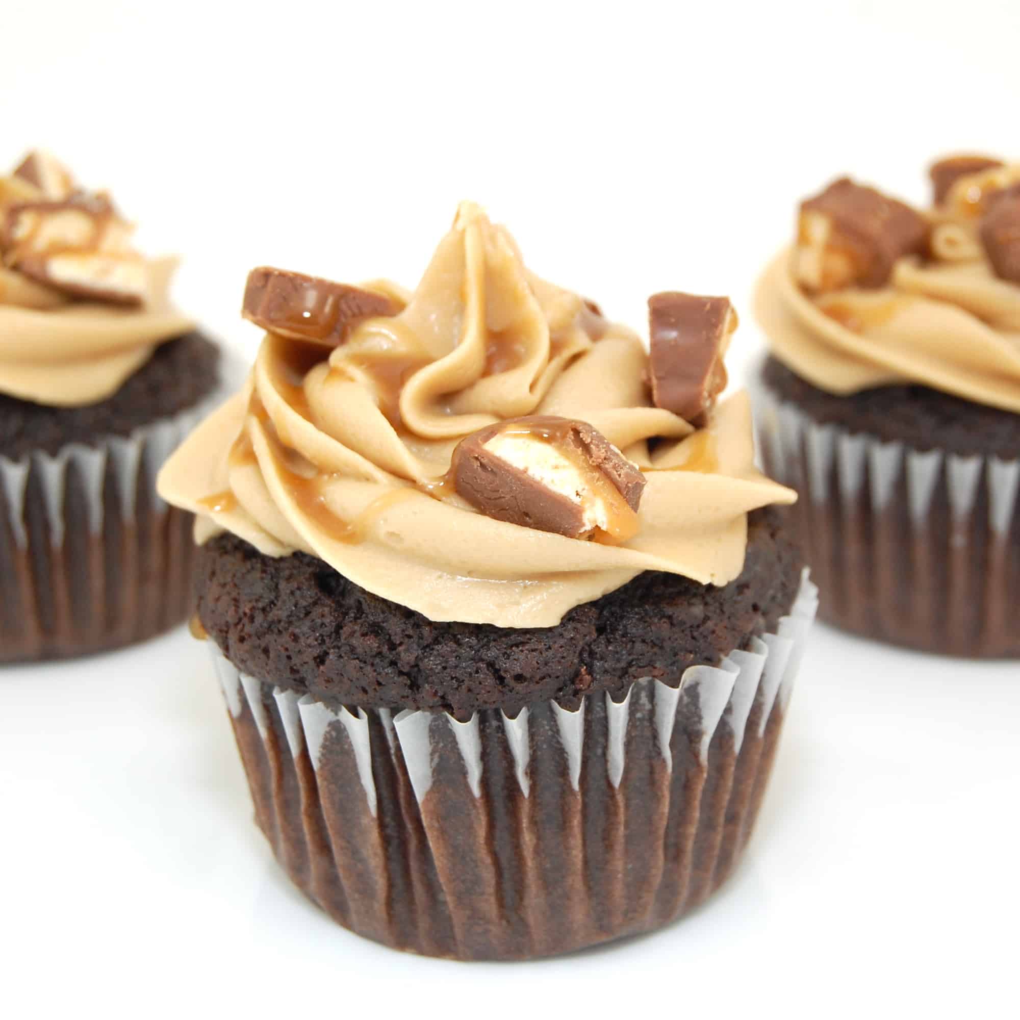 snickers cupcake with caramel frosting and Snickers on top