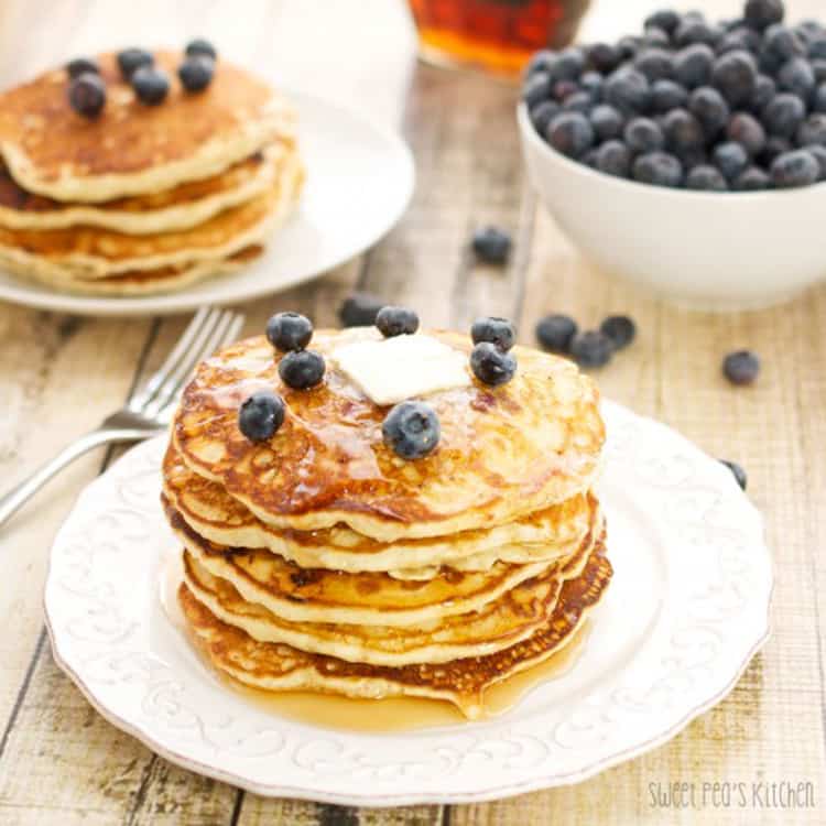 blueberry pancakes on a plate with blueberries