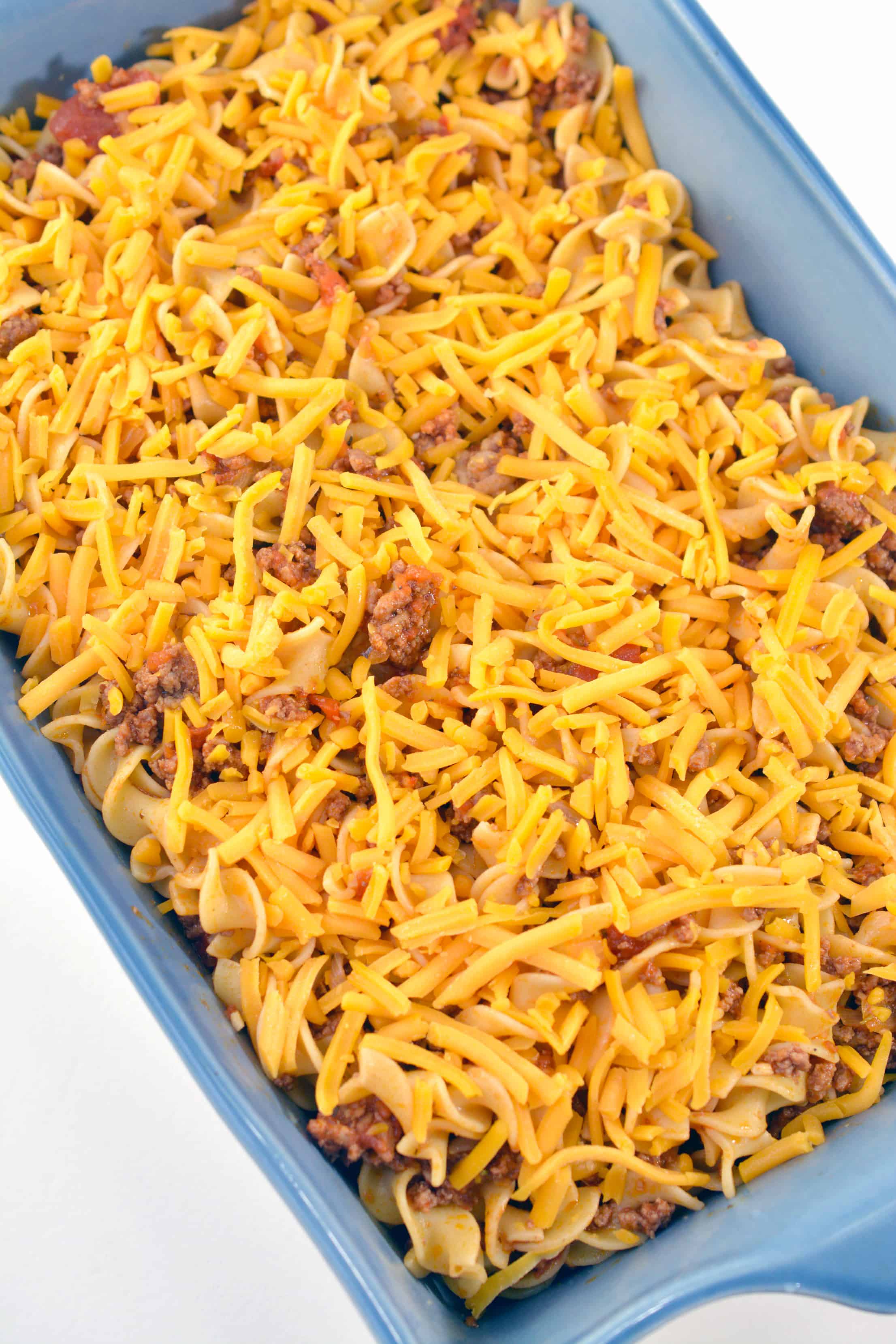 cheese over noodles and beef in casserole dish