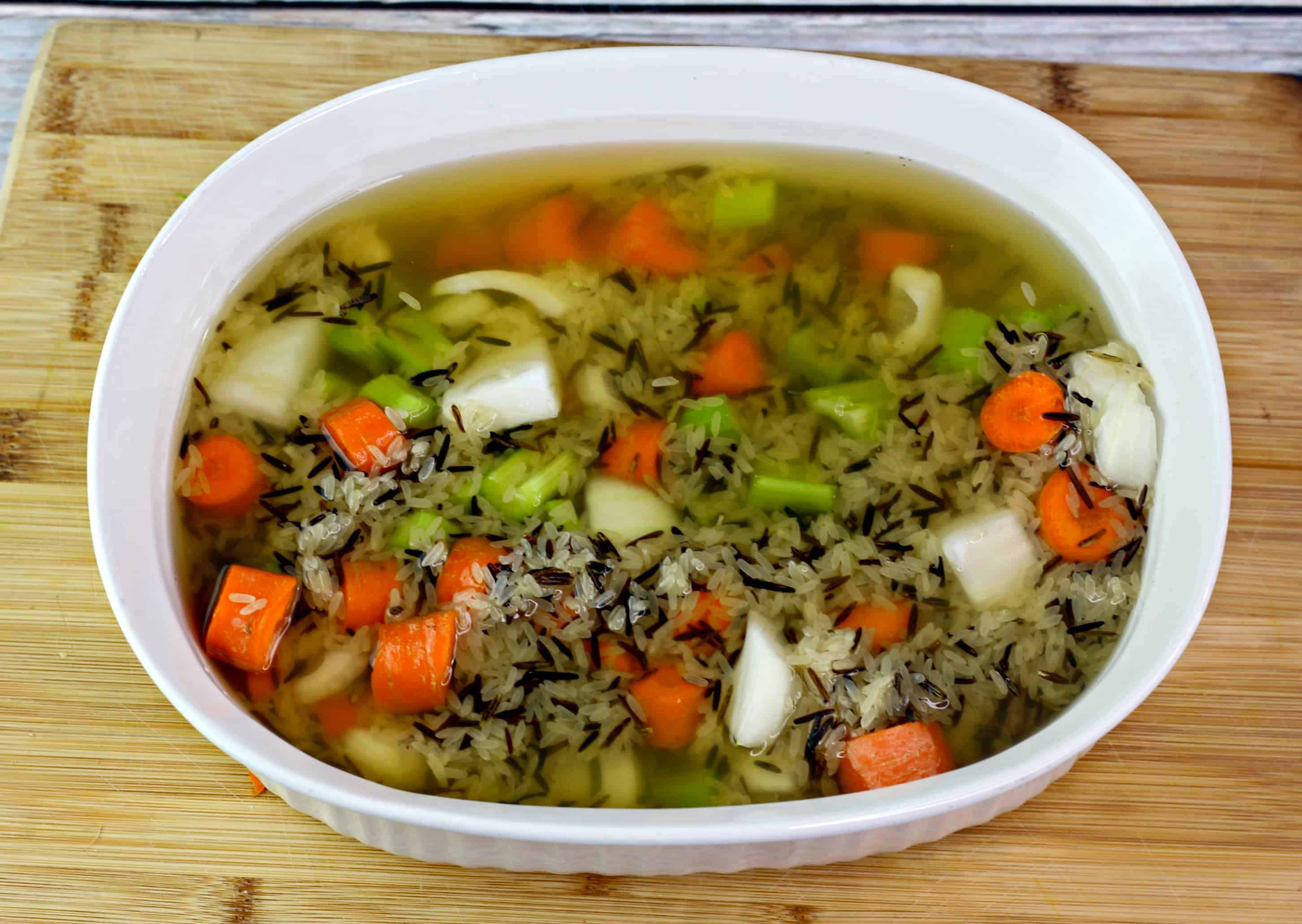wild rice and chicken with broth in a baking dish