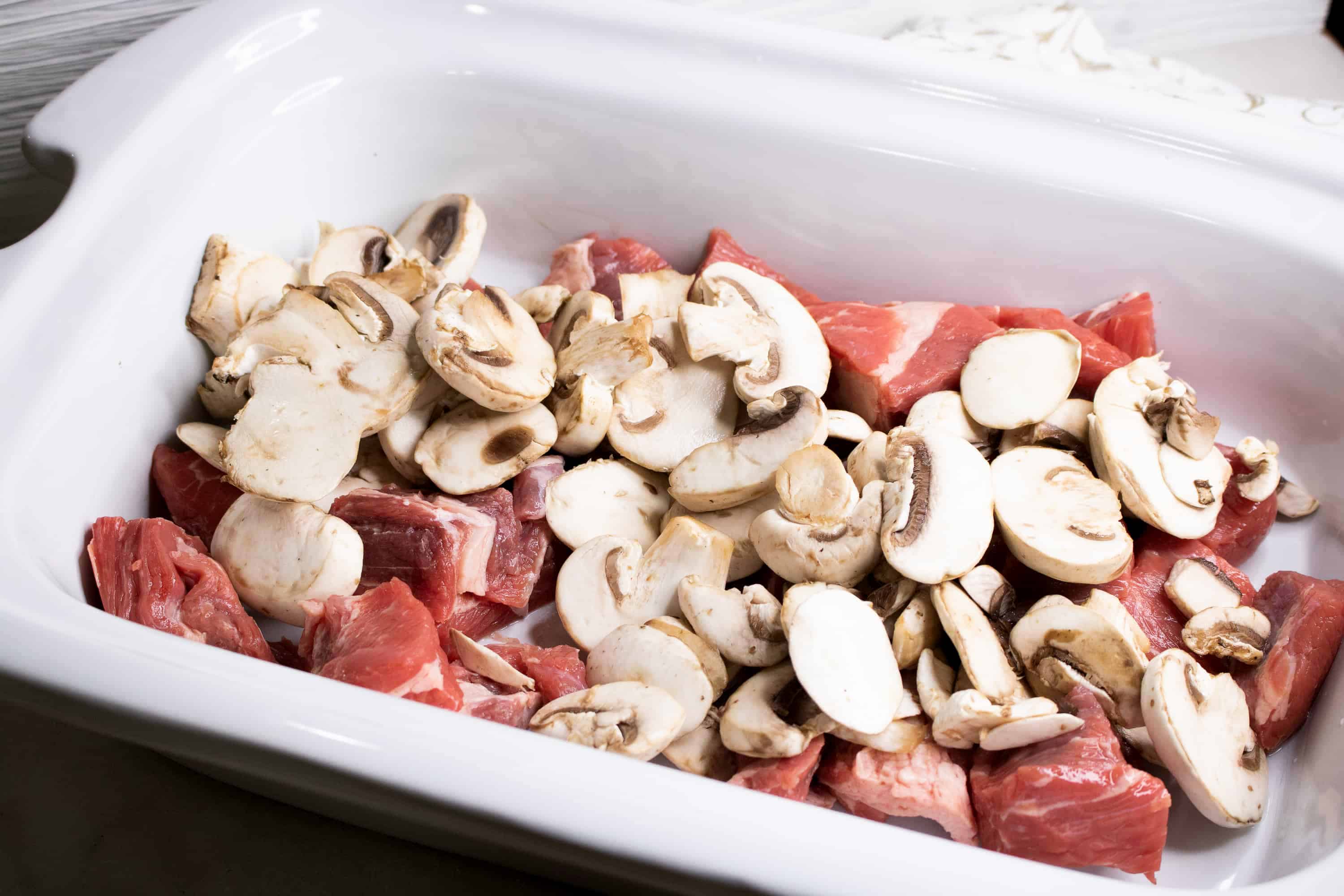 stew meat and mushrooms in a pan