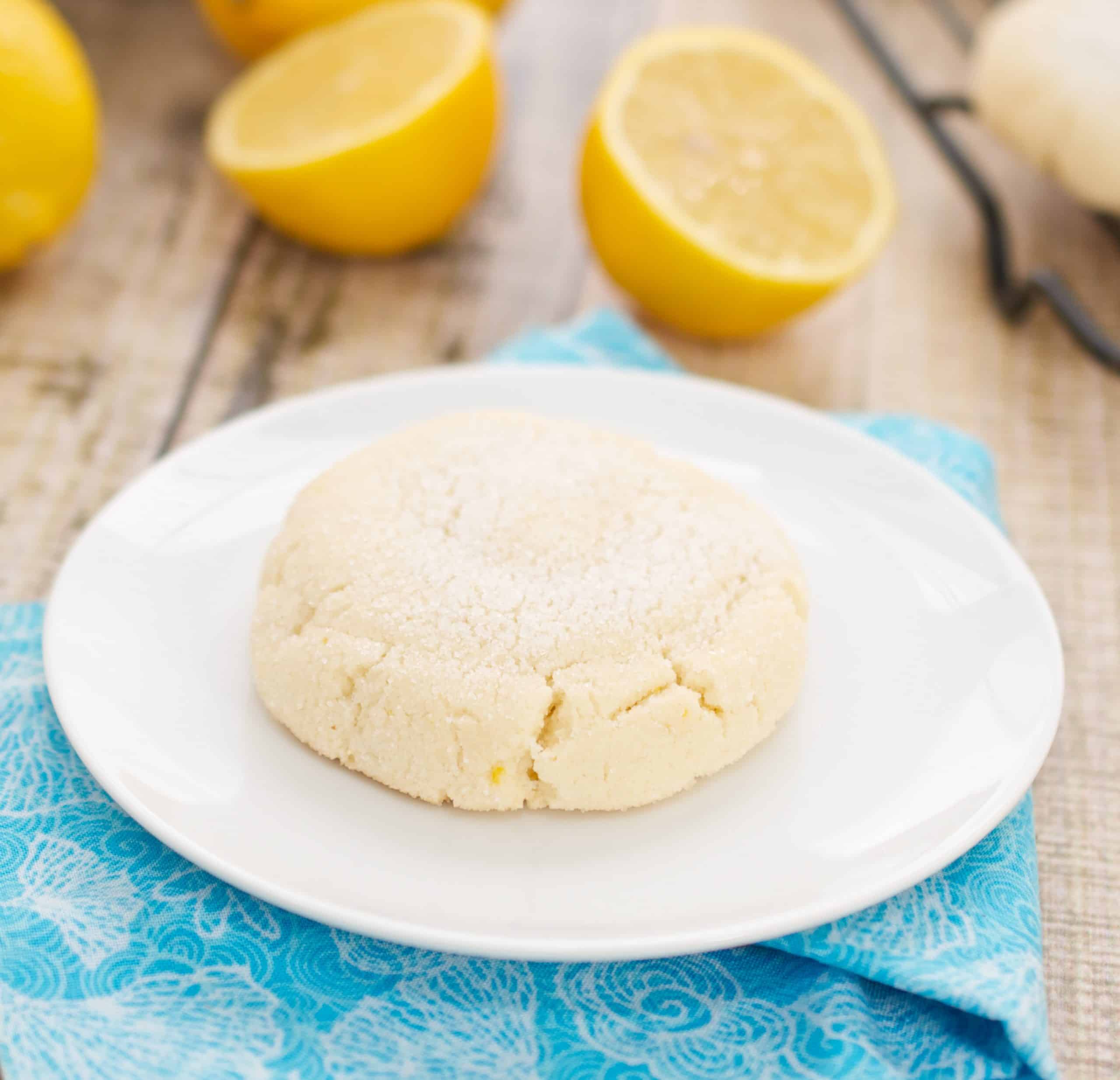 a lemon cookie on a white plate and blue napkin