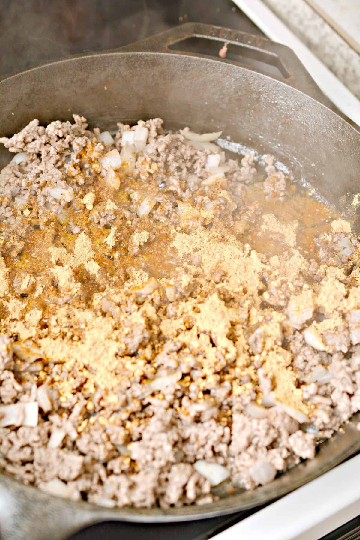 While the cornbread is baking, saute the meat and onions in a skillet over medium-high heat until the meat is browned, and the onions begin to soften.