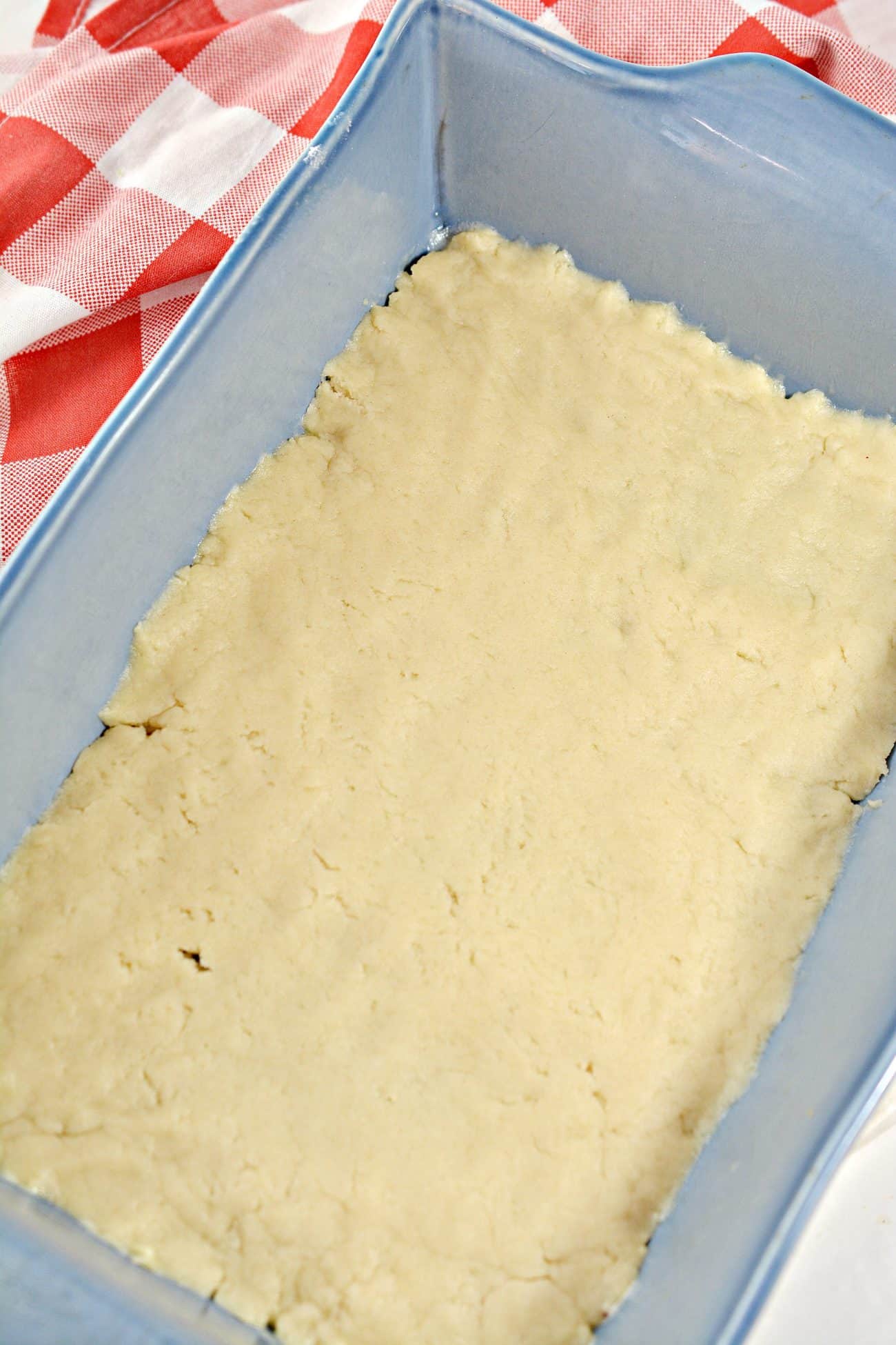 Divide the dough in half, and press half of it into the bottom of a well-greased 9x13 baking dish.