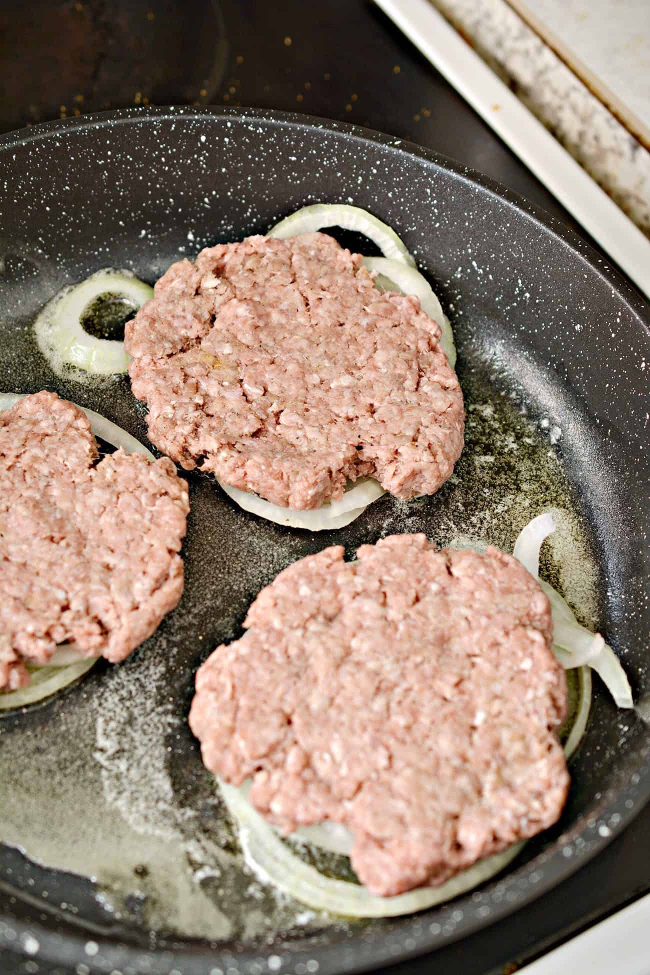 Use a spatula to smoosh the meat mixture flat down on top of the onions.