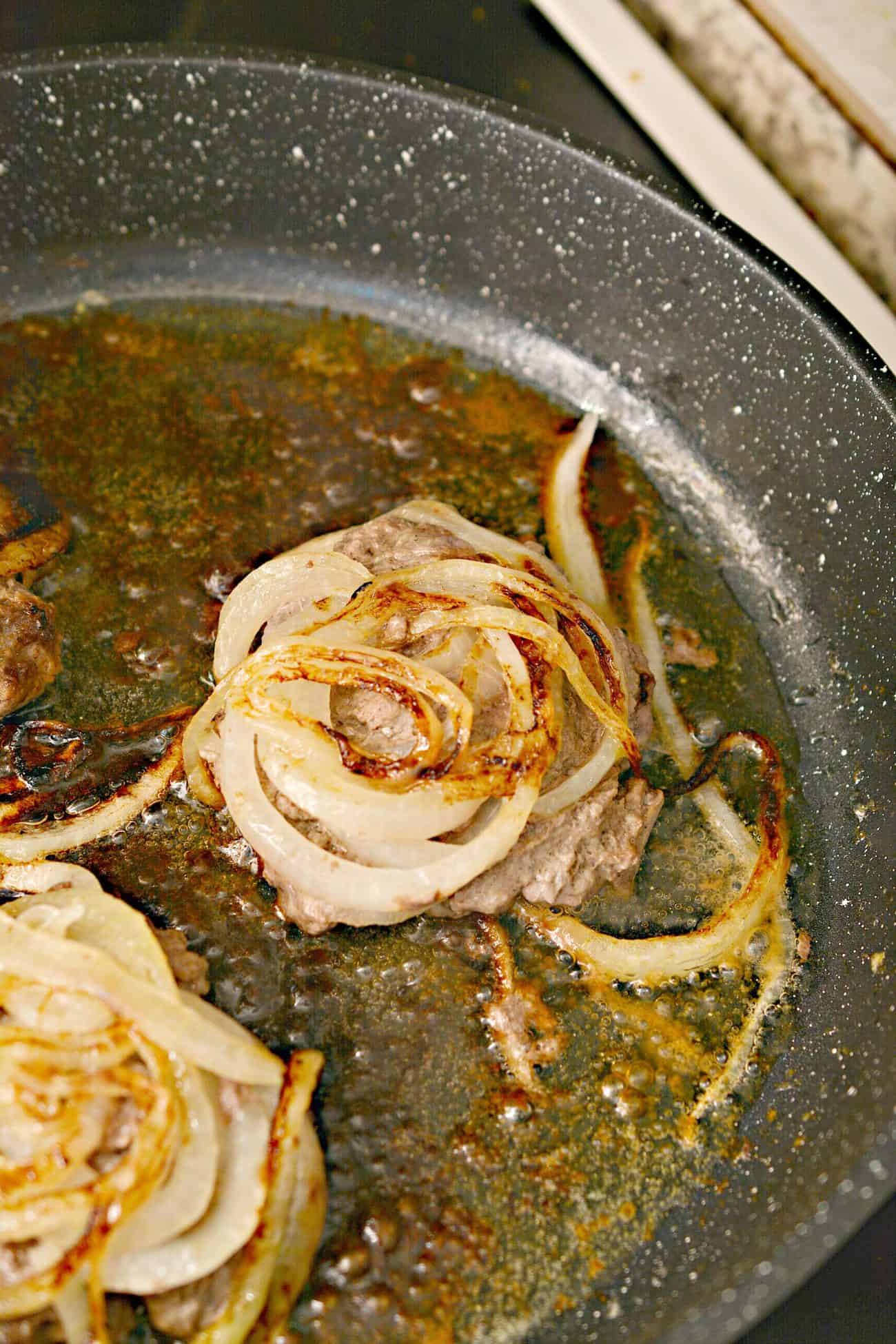 Continue to saute the meat onion side down until the onions have browned, about 6 minutes, then flip and continue to cook the burgers to your liking.