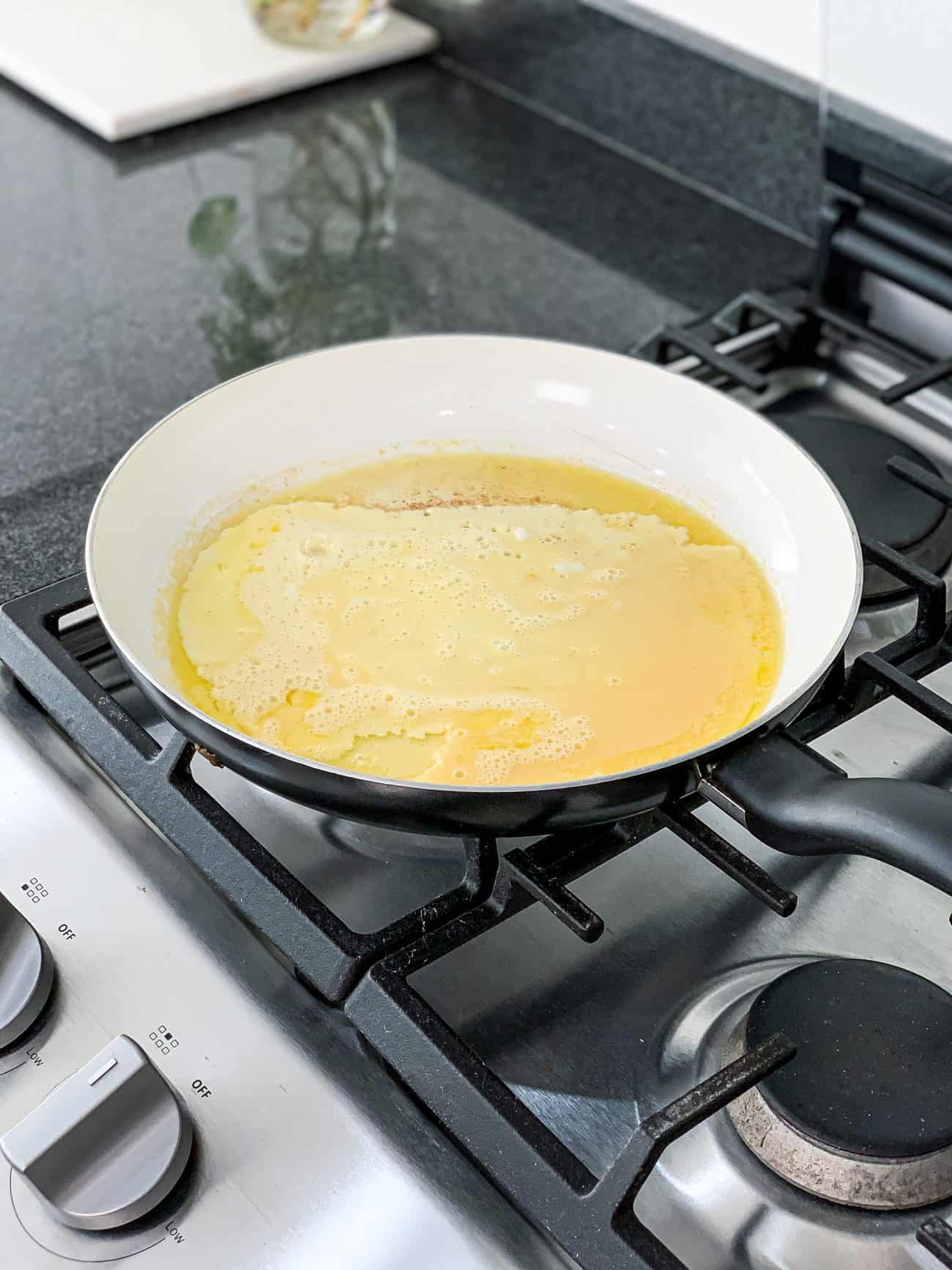 Add egg to the skillet with butter and leave flat for 1 minute. Then flip to cook the other side for another minute.