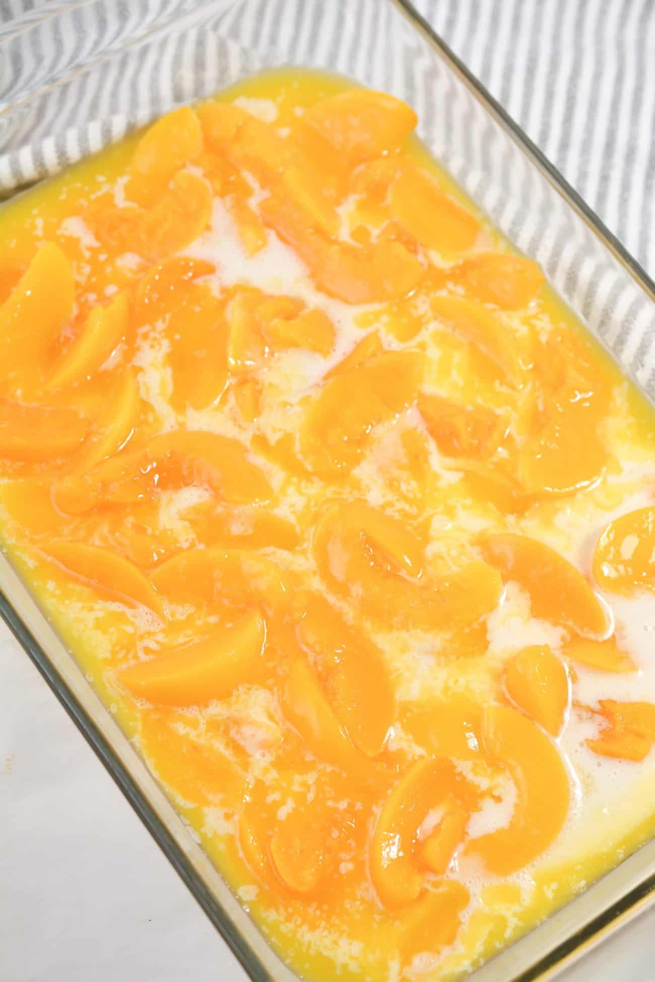 Layer the peach slices on top of the mixture in the dish.