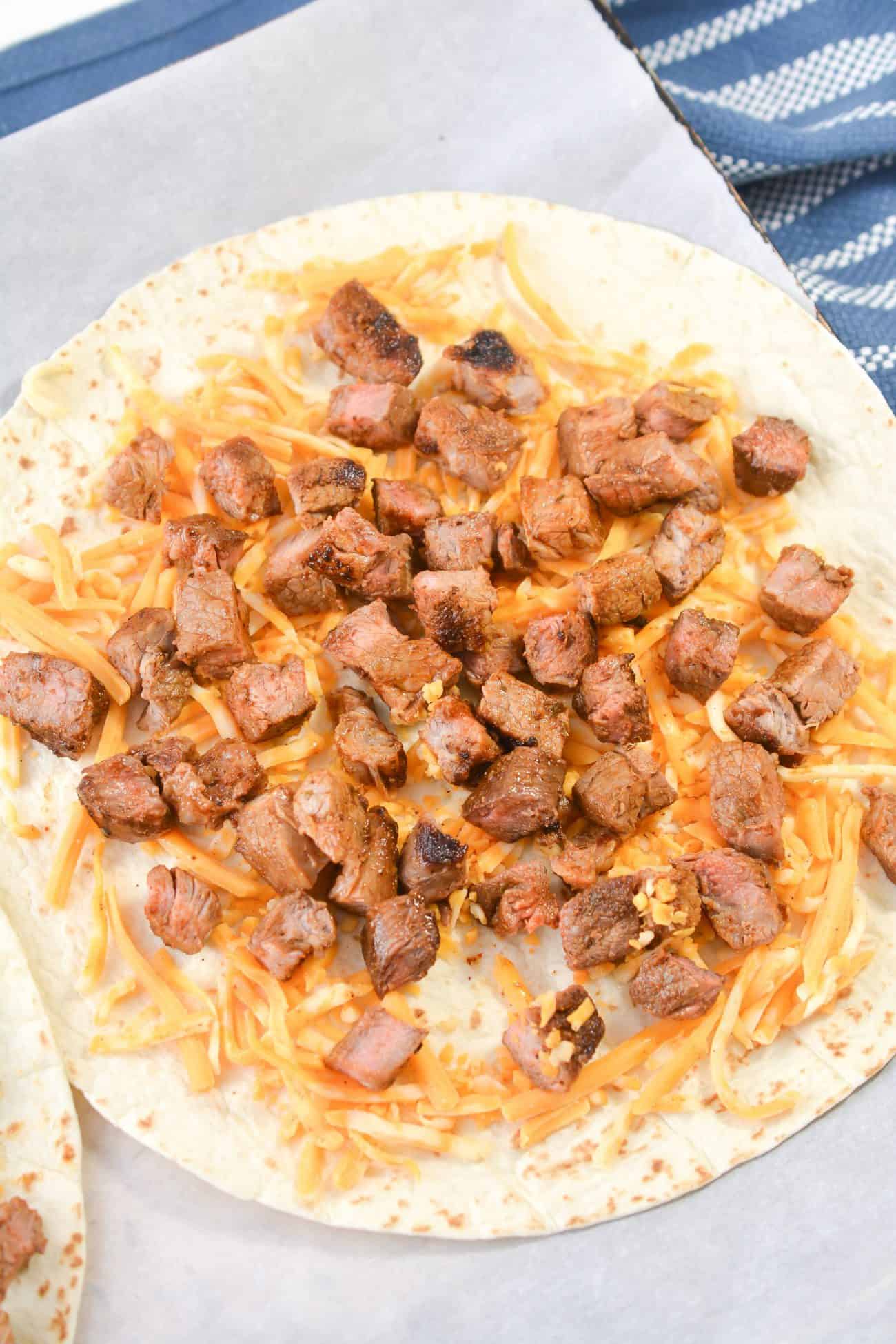 Evenly spread the steak over the two tortillas.