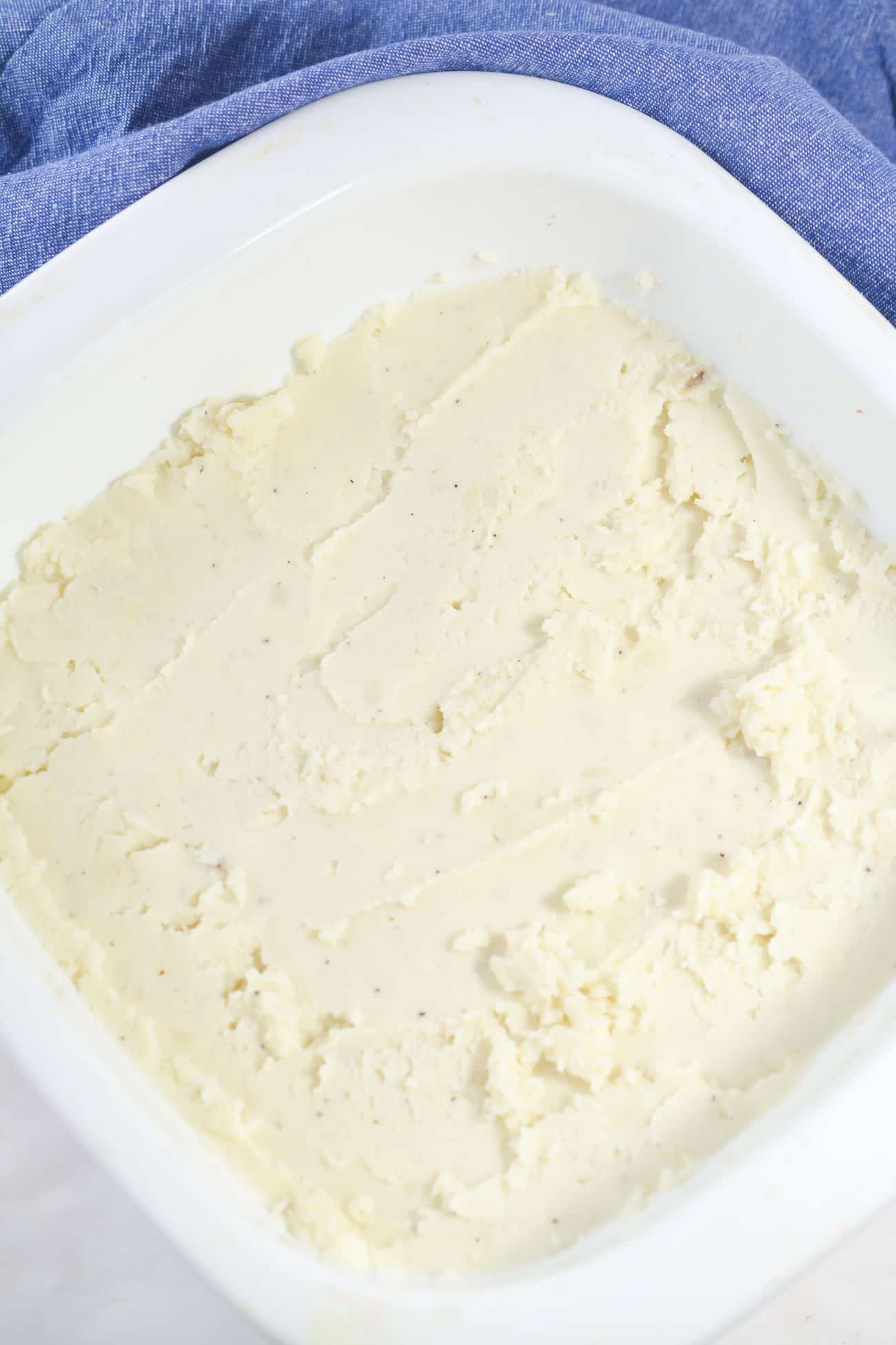 Layer the mashed potatoes on the bottom of a well greased 9x9 baking dish.