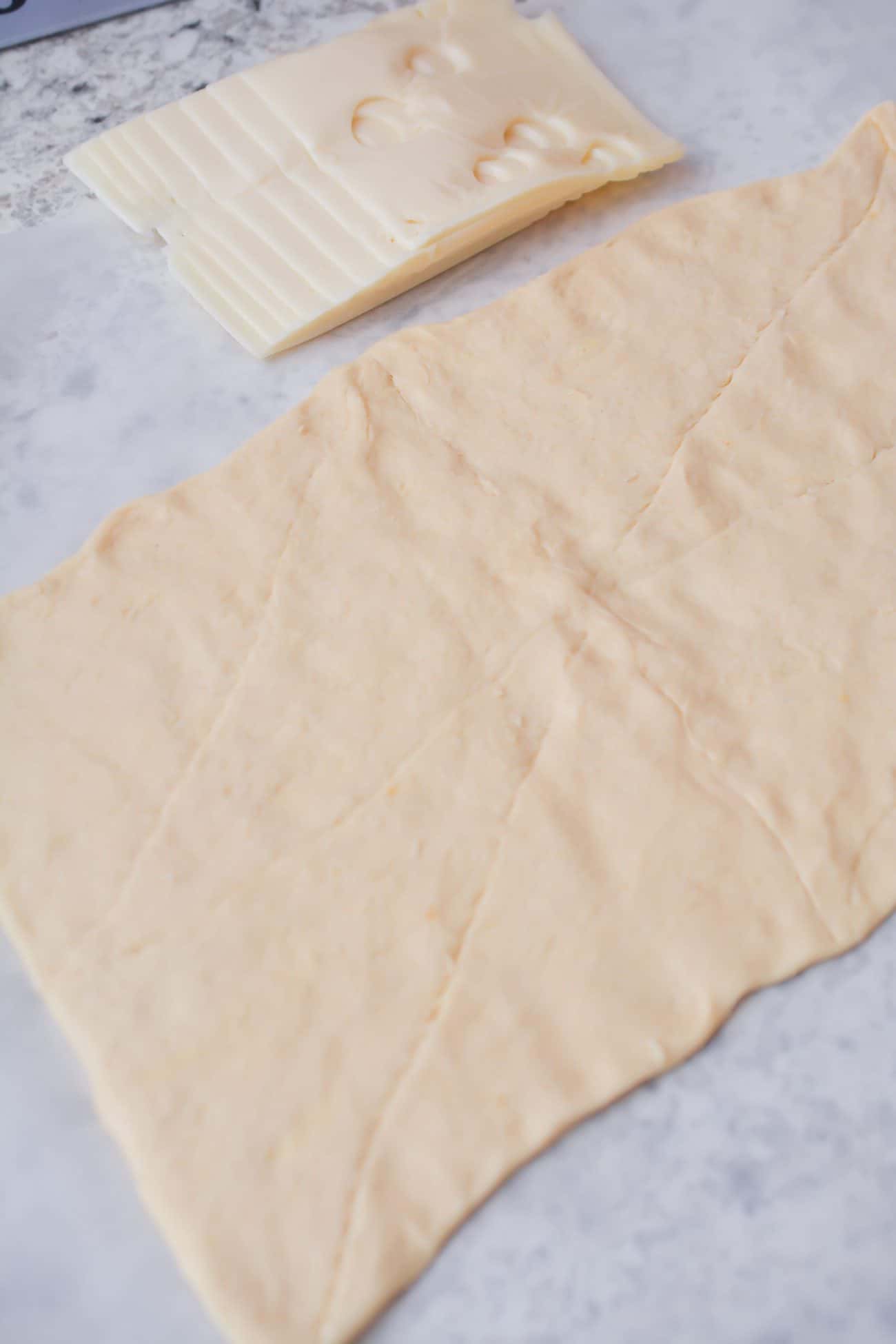 Roll the crescent roll dough out on a parchment-lined surface, and pinch together the seams to form one single sheet of dough.