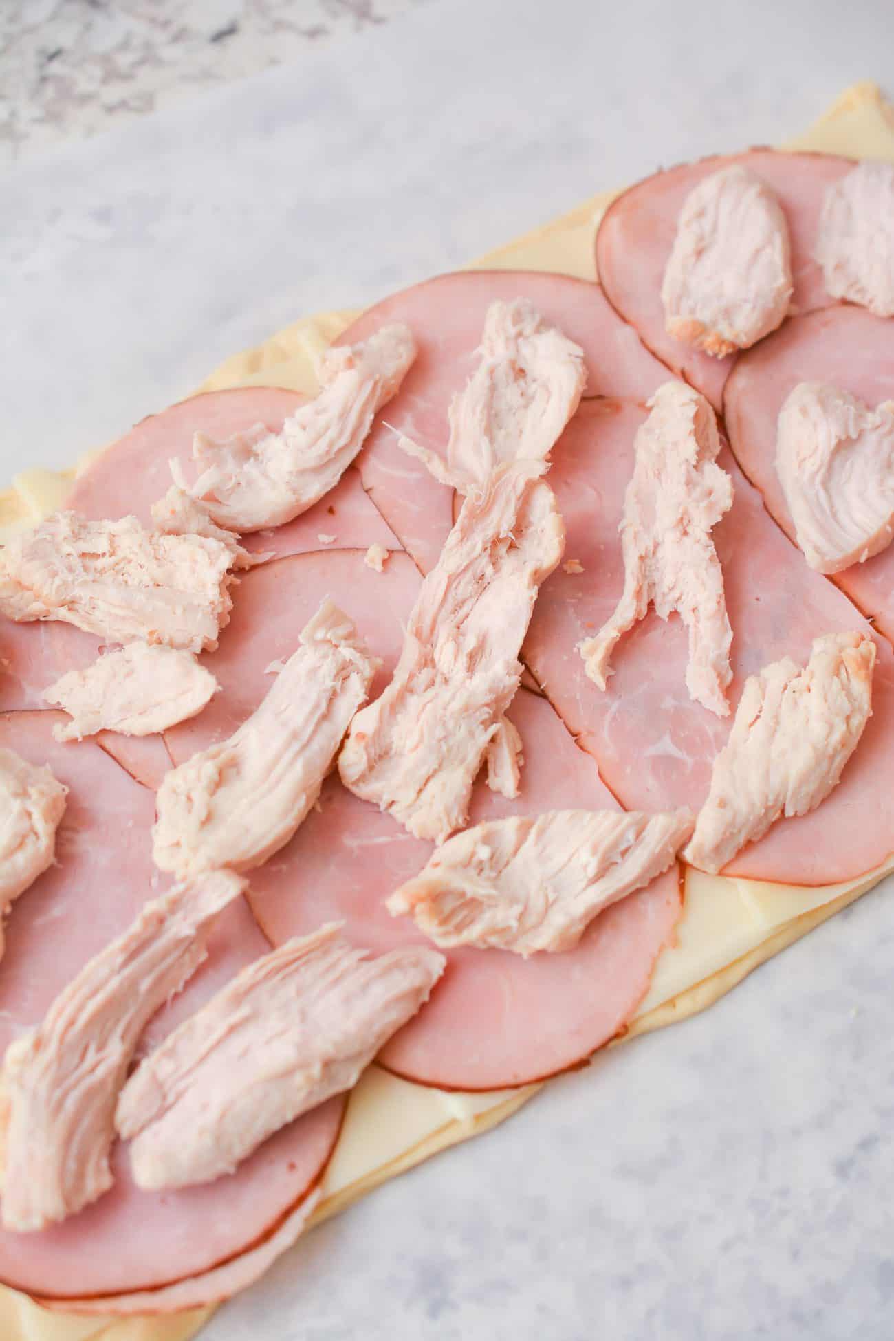 Spread the chicken pieces over the top of the ham slices.