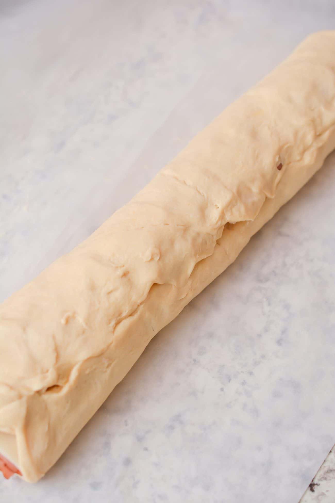 Pinch together the seams at the end to seal the dough over the filling.