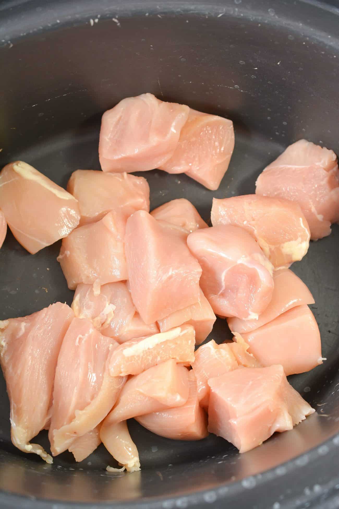 Layer 2 lb. Chicken breasts cut into pieces to the bottom of the crockpot.