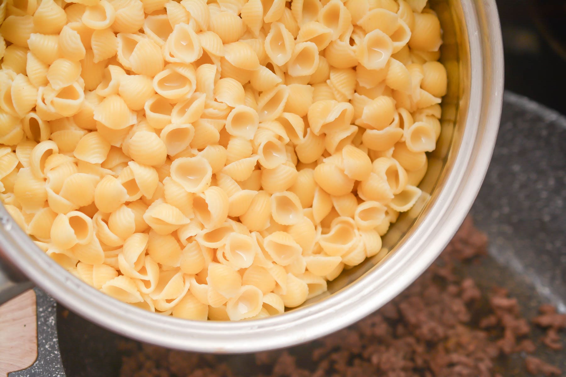 Add the ground beef, pasta, and ½ of the cheese.