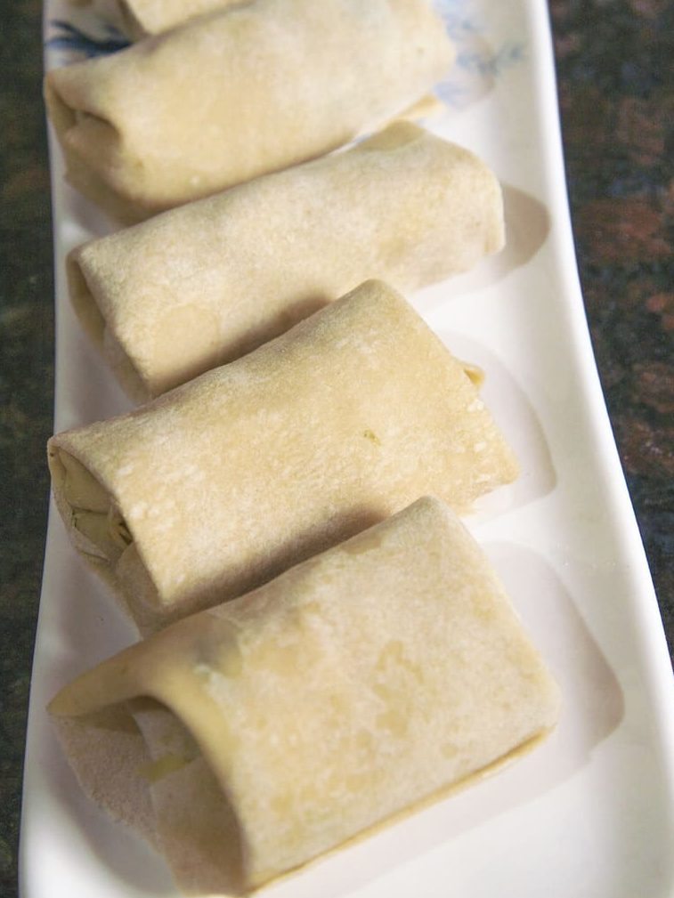 Secure the egg roll in place by adding a dab of water to the center and roll the wrap upwards