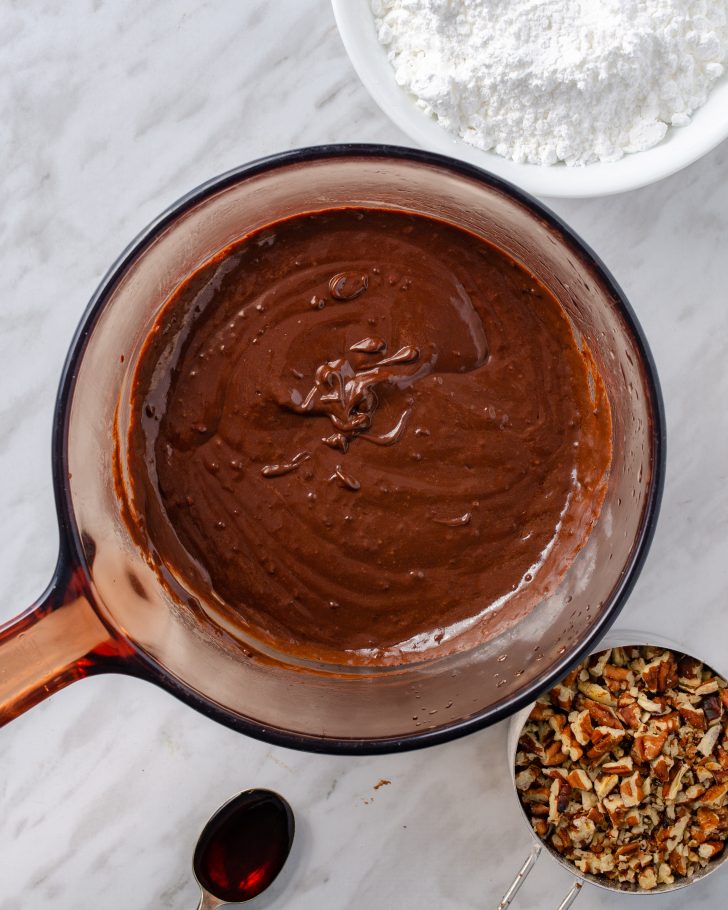 Prepare the Texas sheet cake frosting by placing the butter, cream, cocoa, and corn syrup in a large saucepan over medium heat.