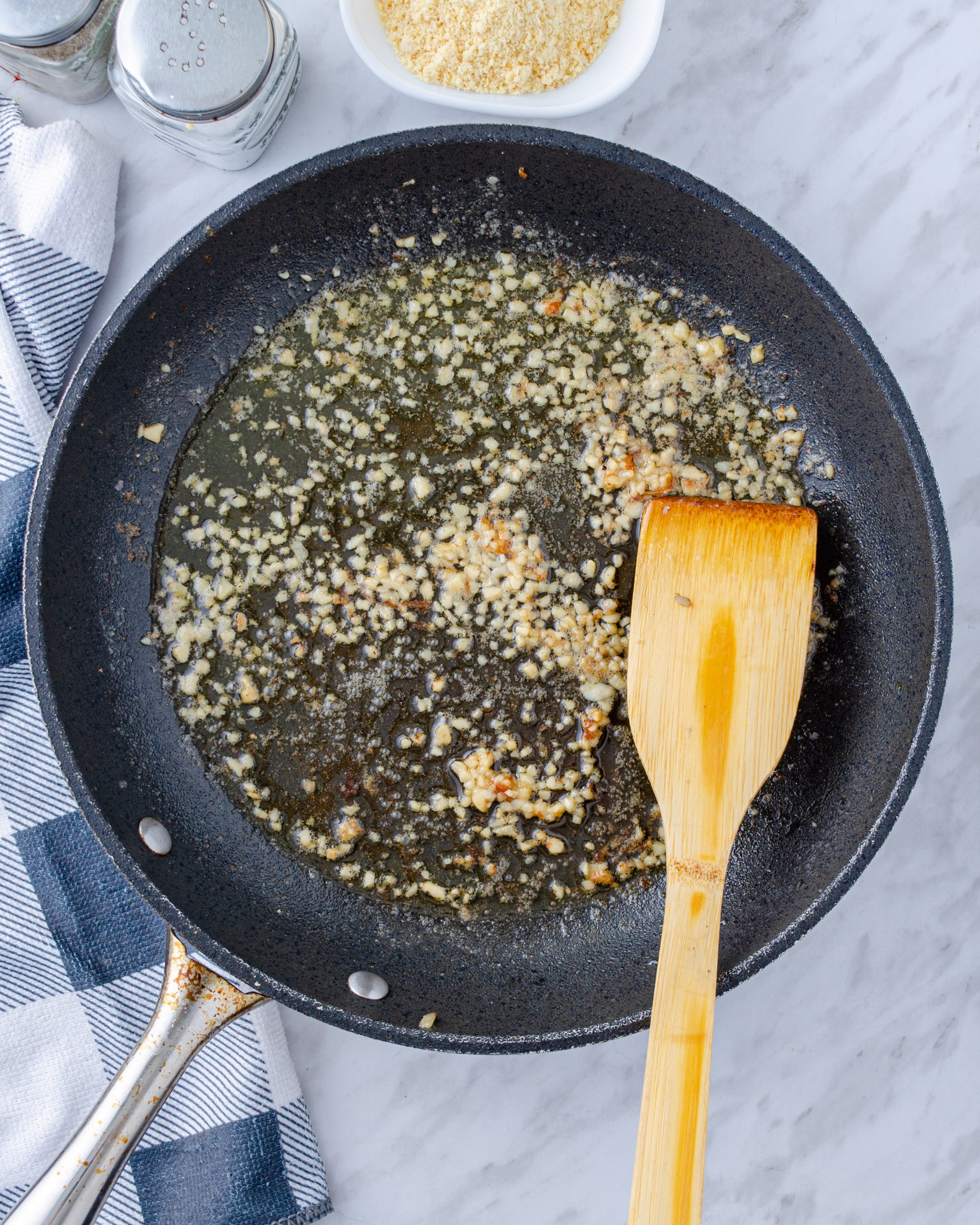 Reduce the heat to medium, and add the butter and garlic to the skillet. Saute until the butter is melted.