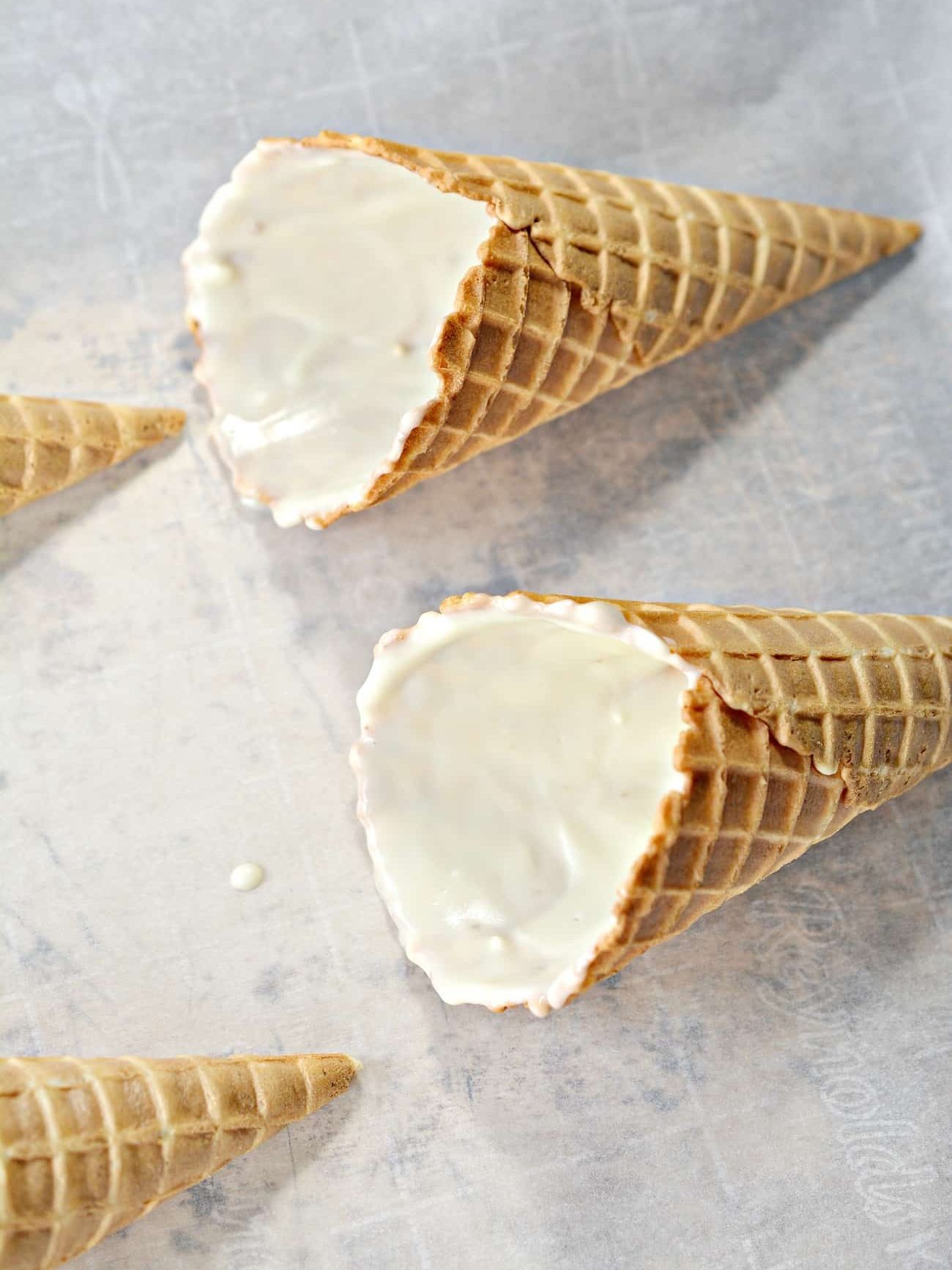 Coat the inside of each waffle cone with the white chocolate, and place on a parchment or silicone mat-lined baking sheet to set.