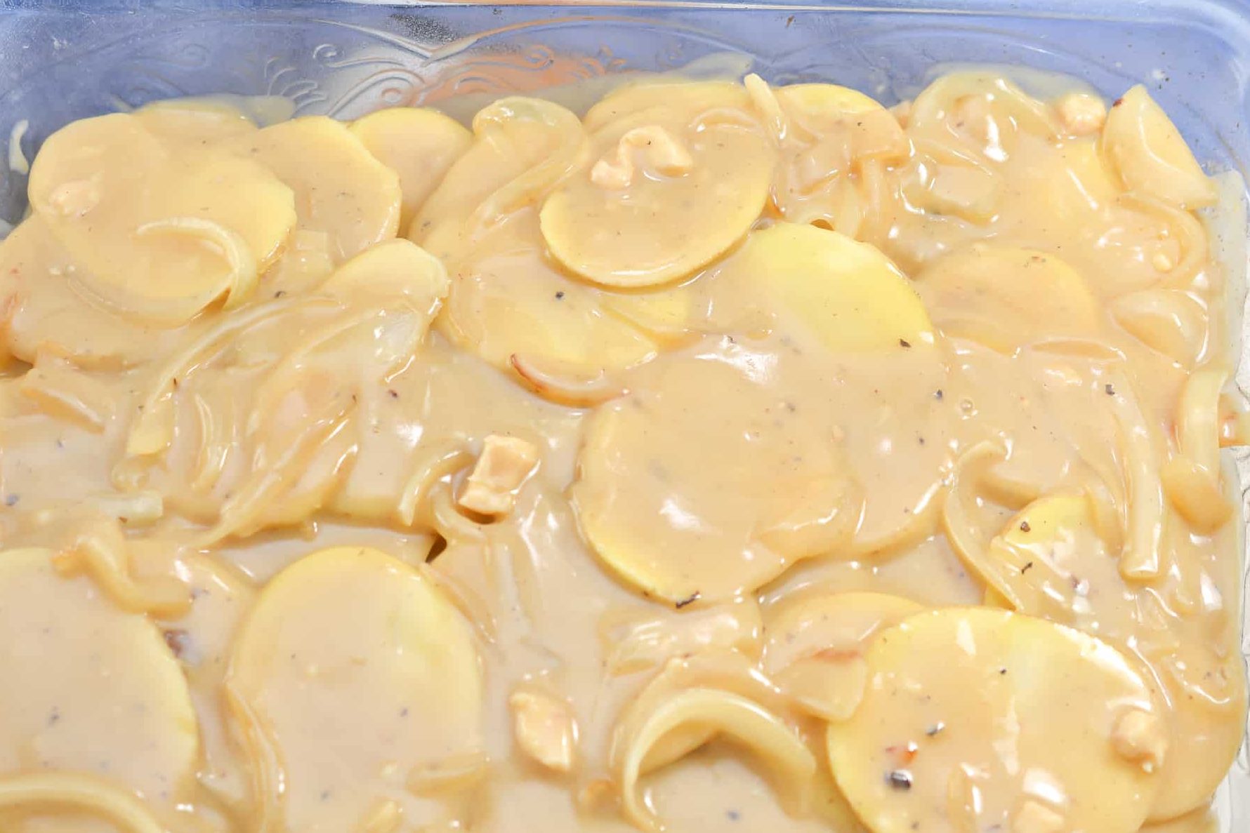 Pour the gravy mixture over the potatoes in the casserole dish.