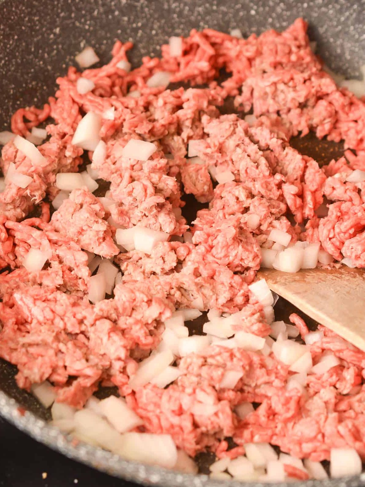 Add the ground beef and onion to a skillet over medium-high heat on the stove.