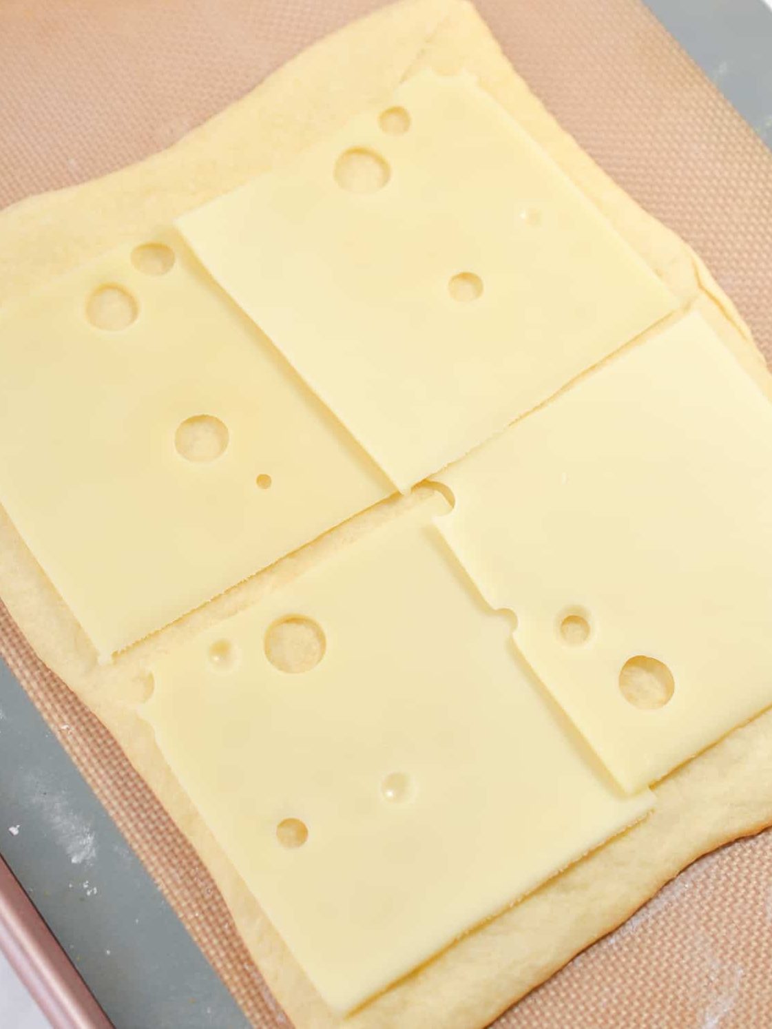 Remove the crust from the oven and top with four slices of swiss cheese.