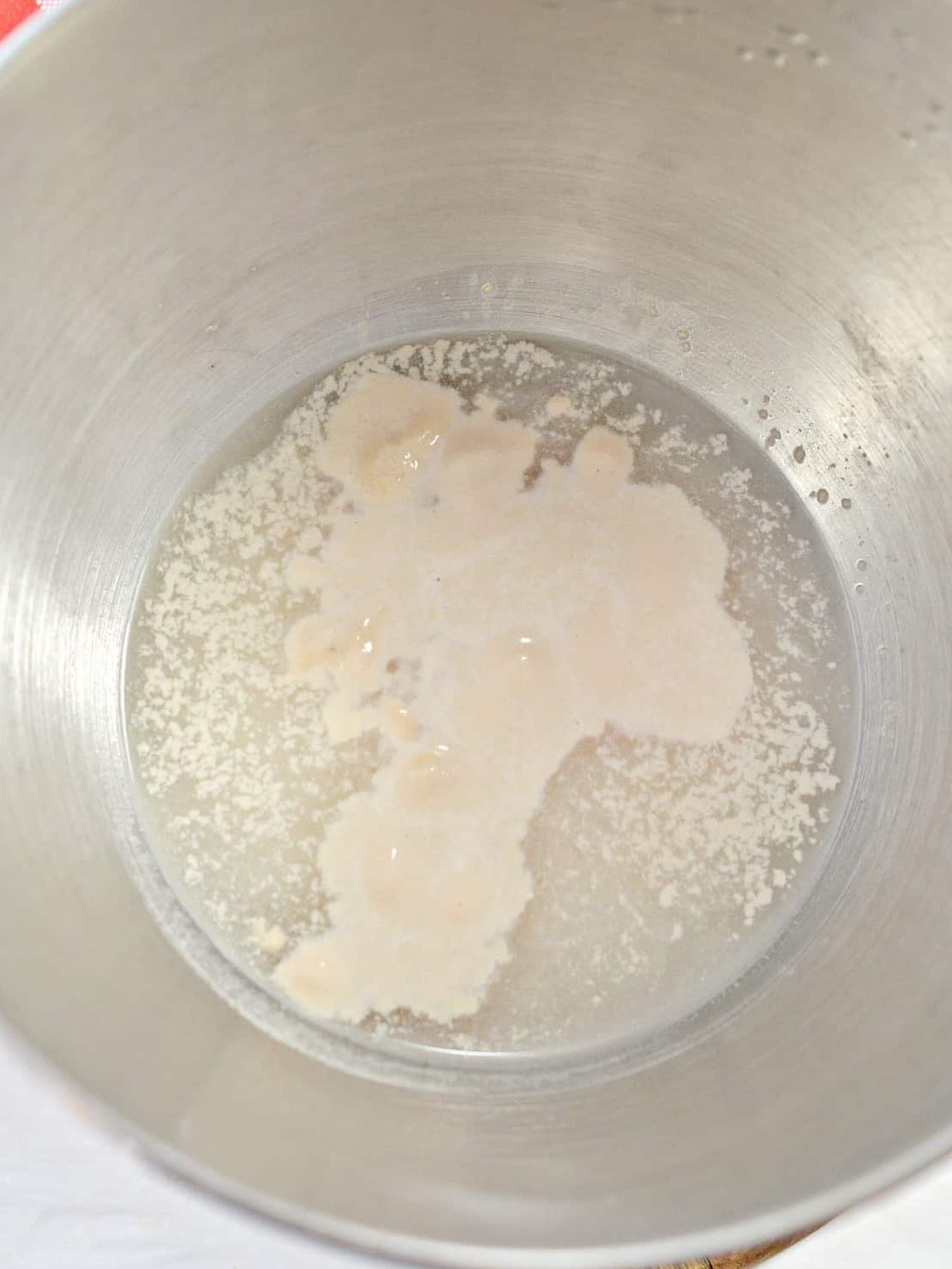 Add the yeast and water to a large mixing bowl and allow to sit to bloom for 10 minutes.