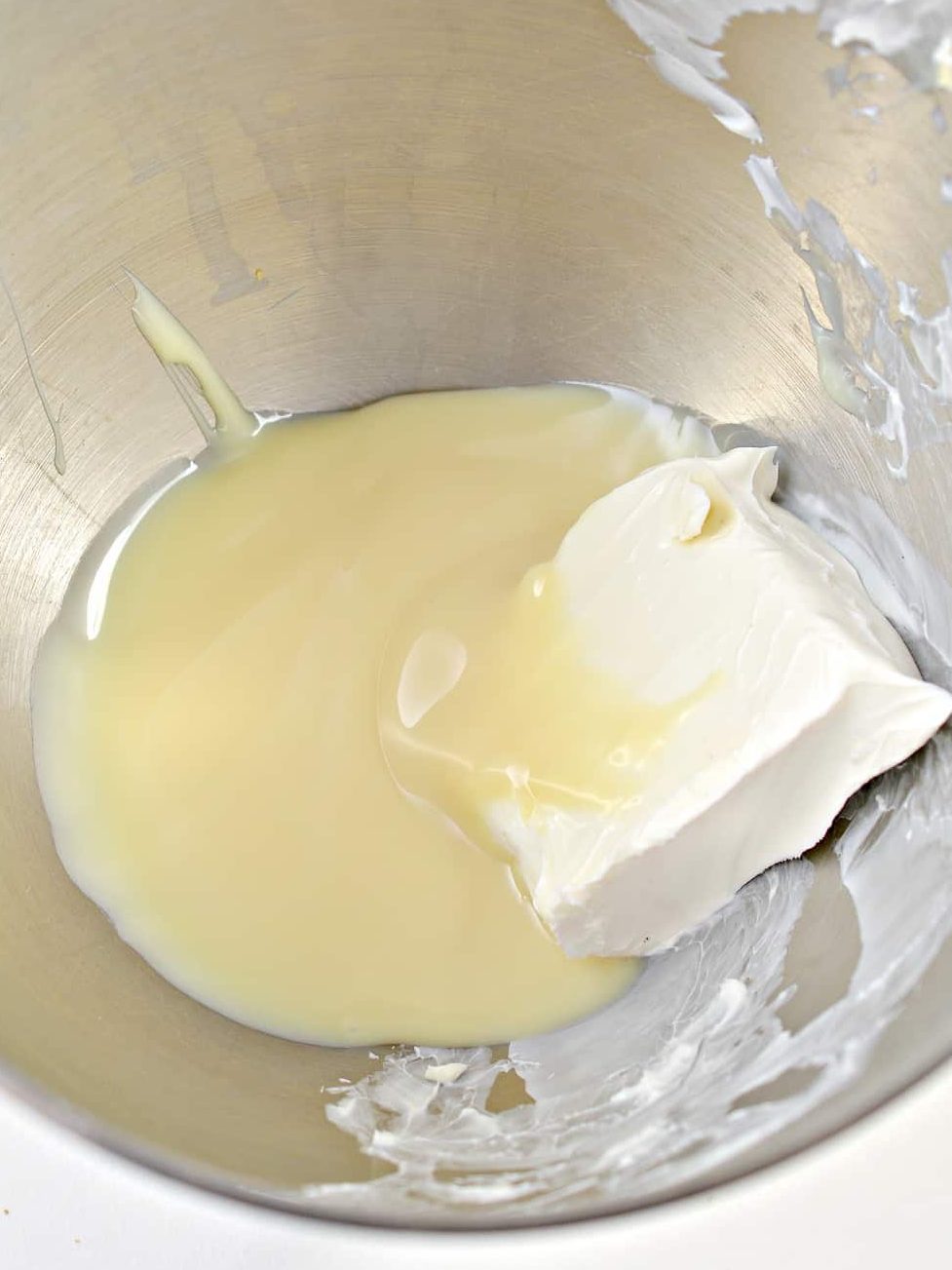 In a mixing bowl, beat together the cream cheese and sweetened condensed milk until smooth.