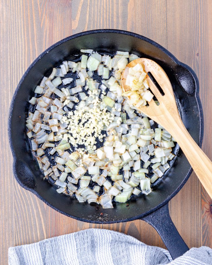 Place the bacon grease in a deep side pot or skillet, and cook the onion until it is softened.