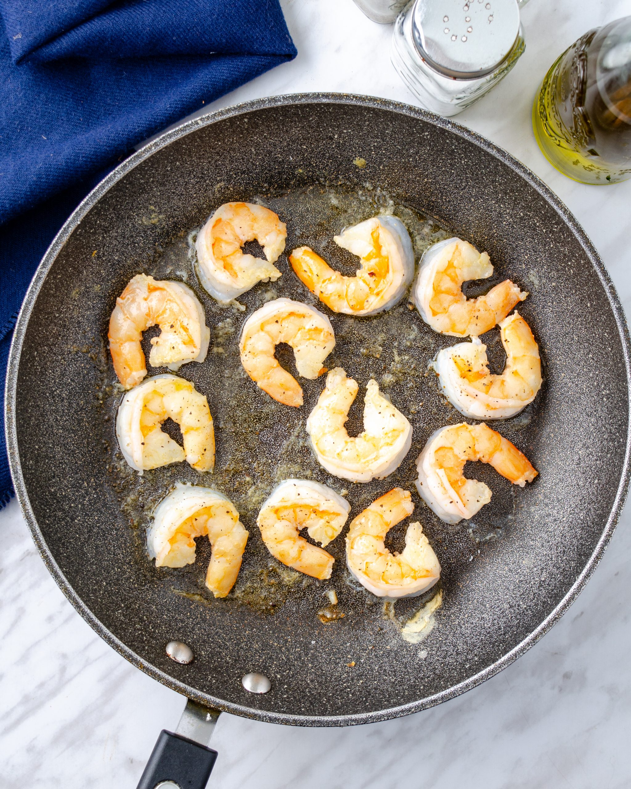 Season the shrimp with salt and pepper and saute in the skillet until cooked through.