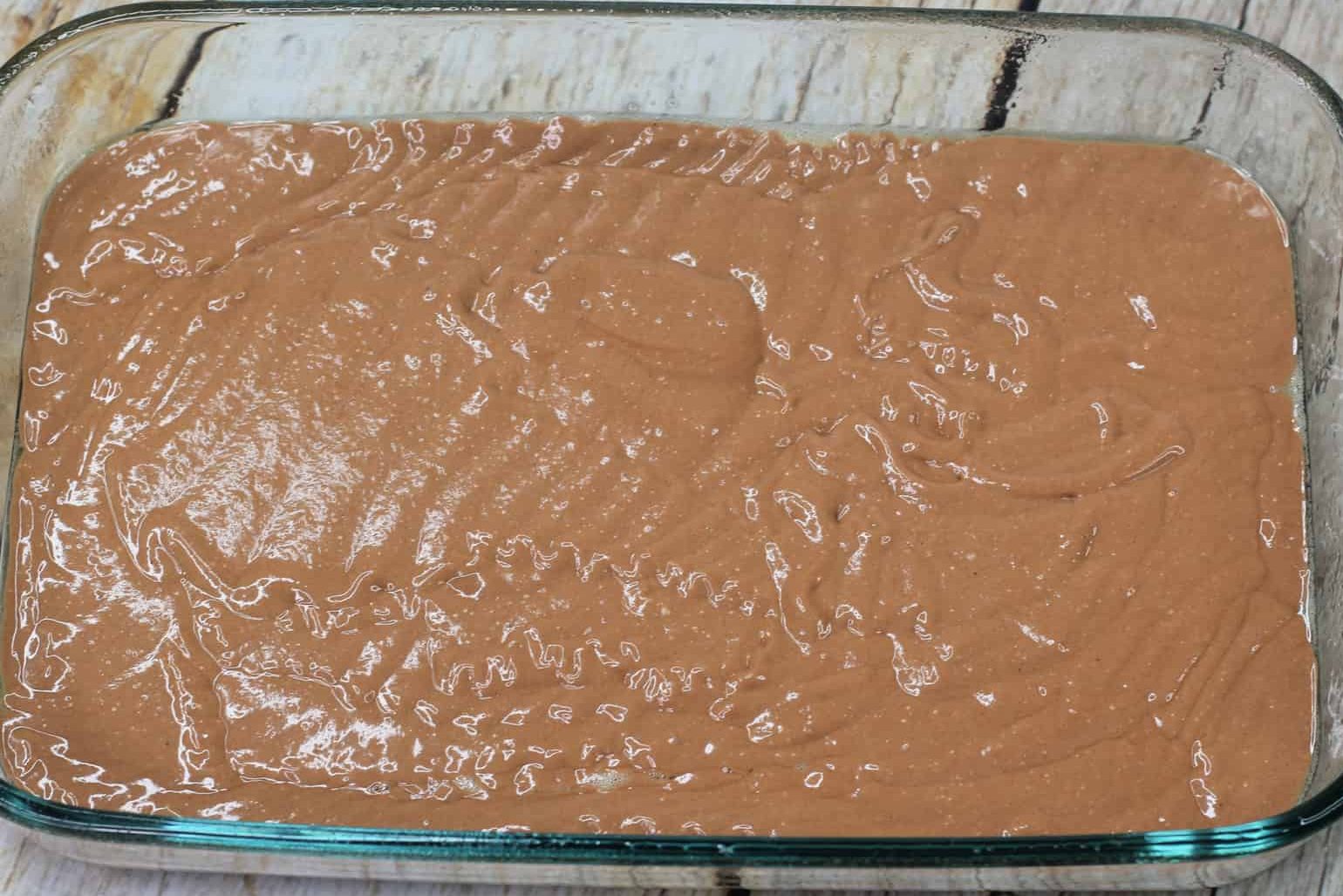 Pour half of the cake batter into the baking dish 