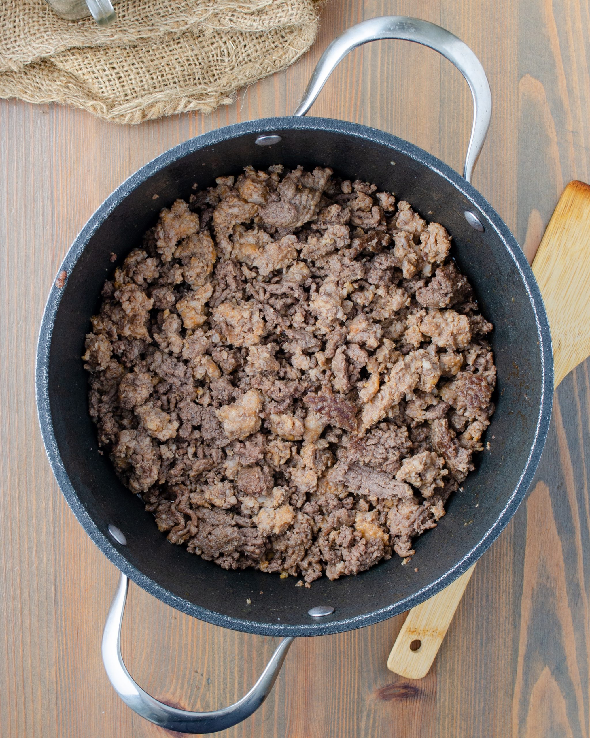 Add the ground beef, onion, and sausage to a large pot over medium-high heat, and cook until completely browned. Drain any excess fat. 